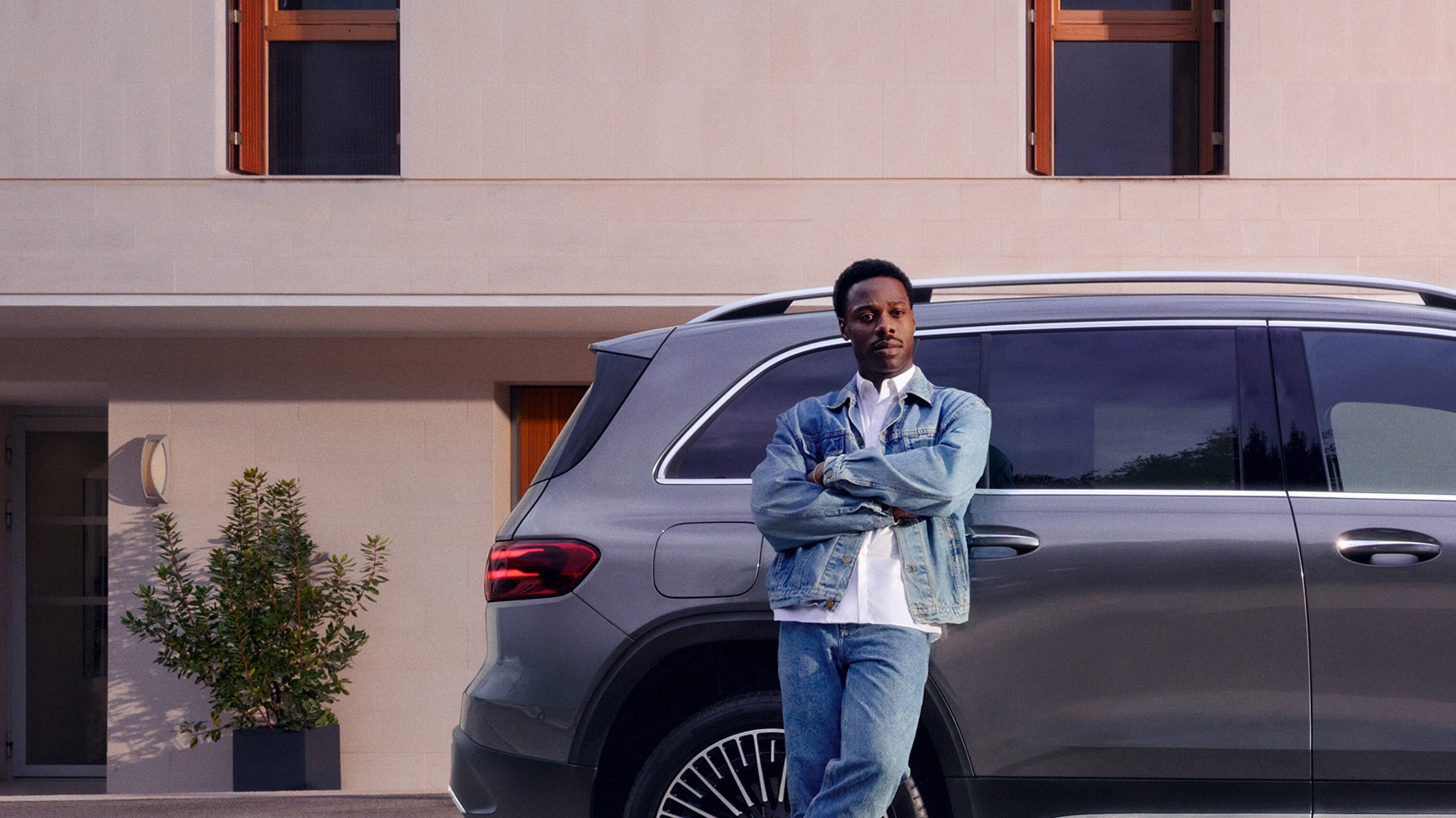 A man leaning against a car.