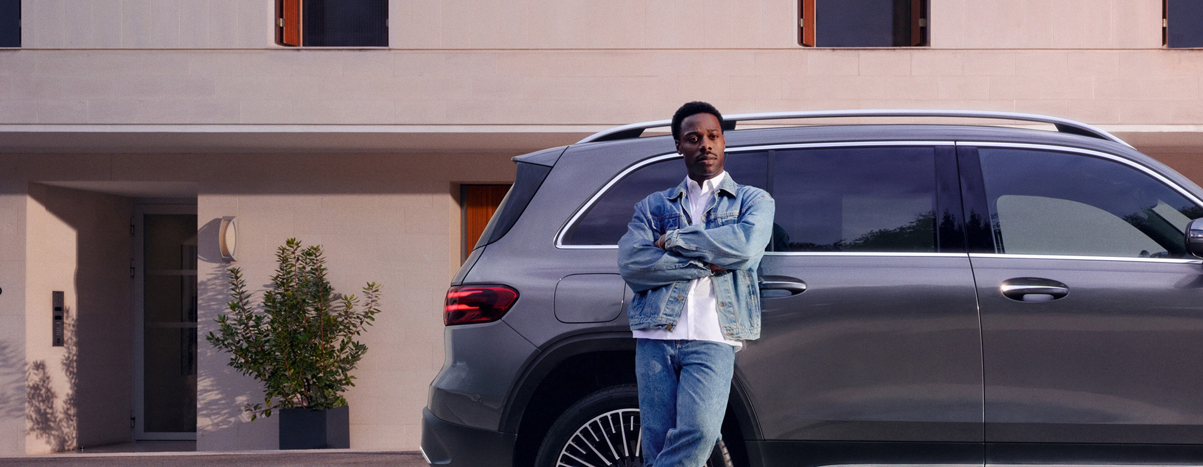 A man leaning against a car