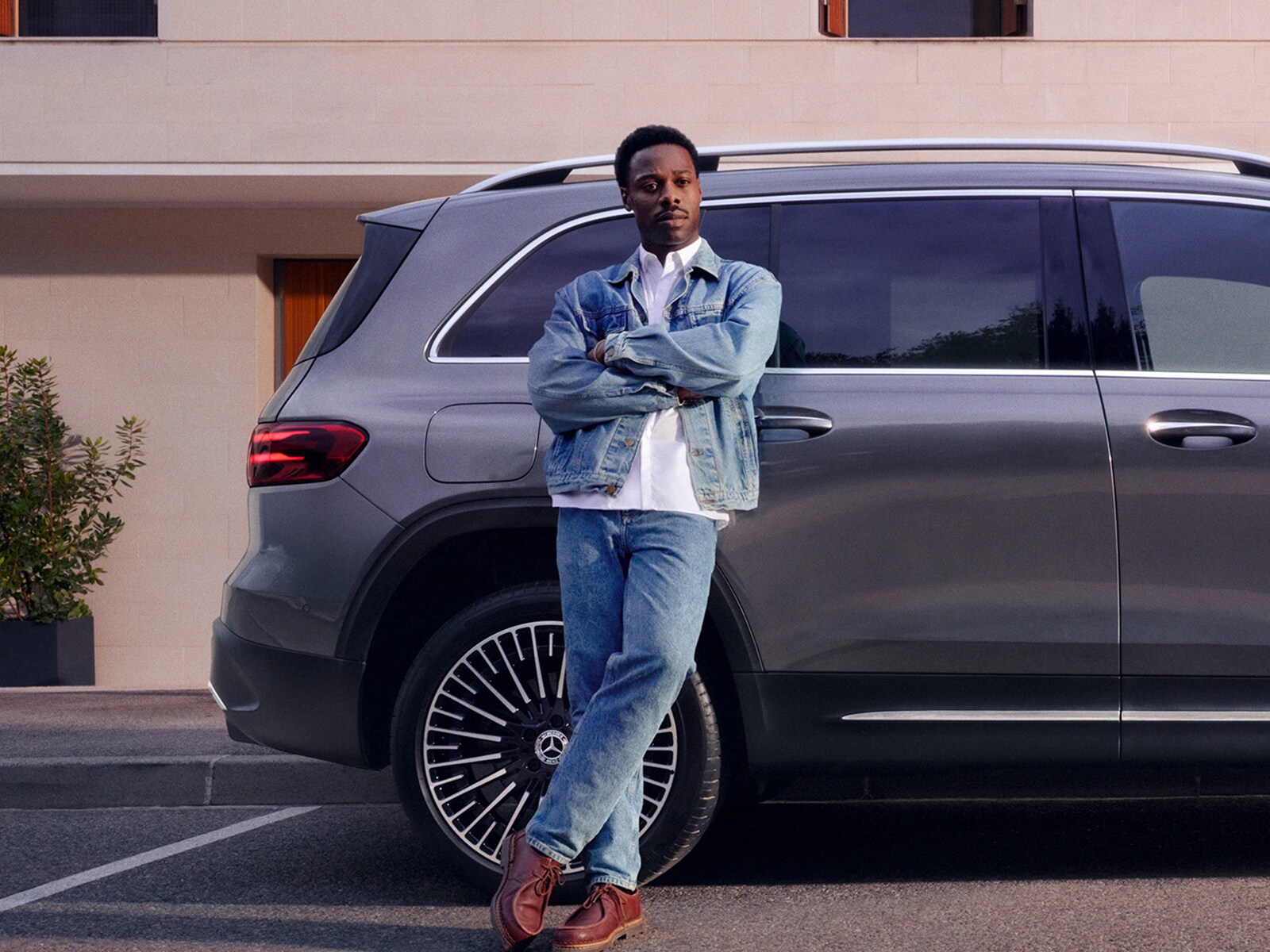 A man leaning against a car