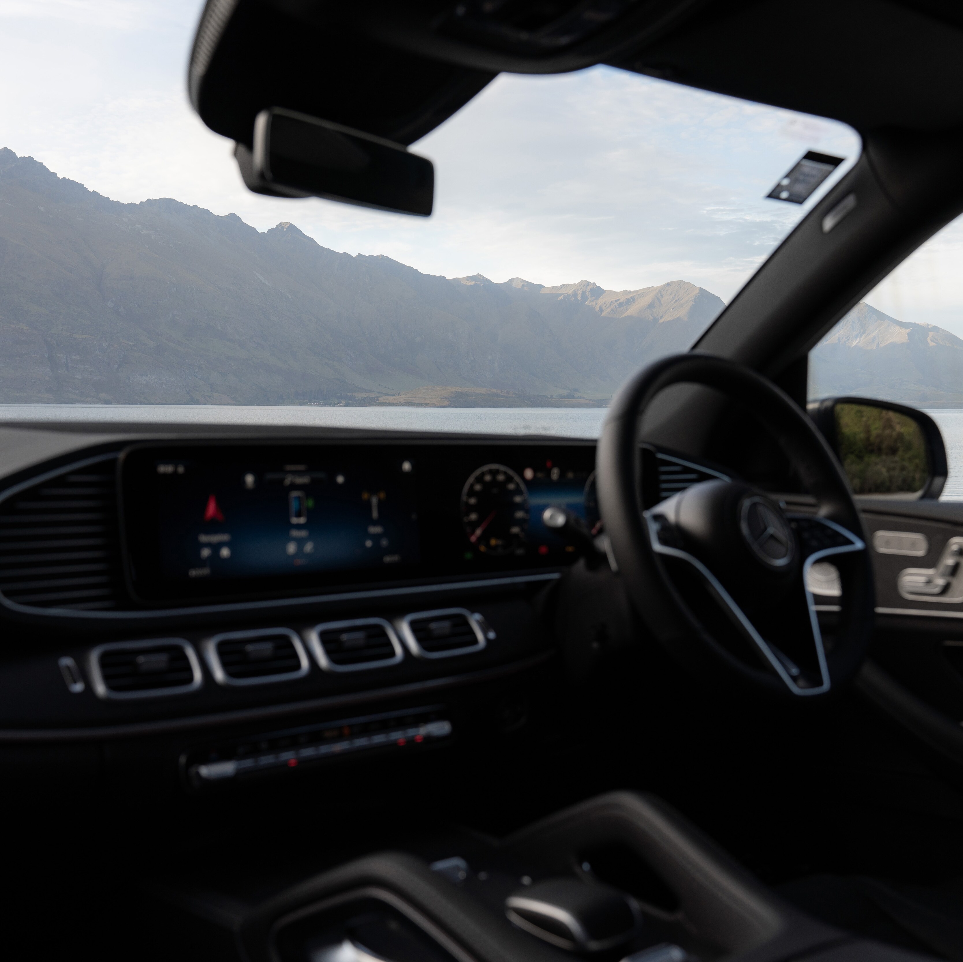 A car dashboard with a view of the mountains.
