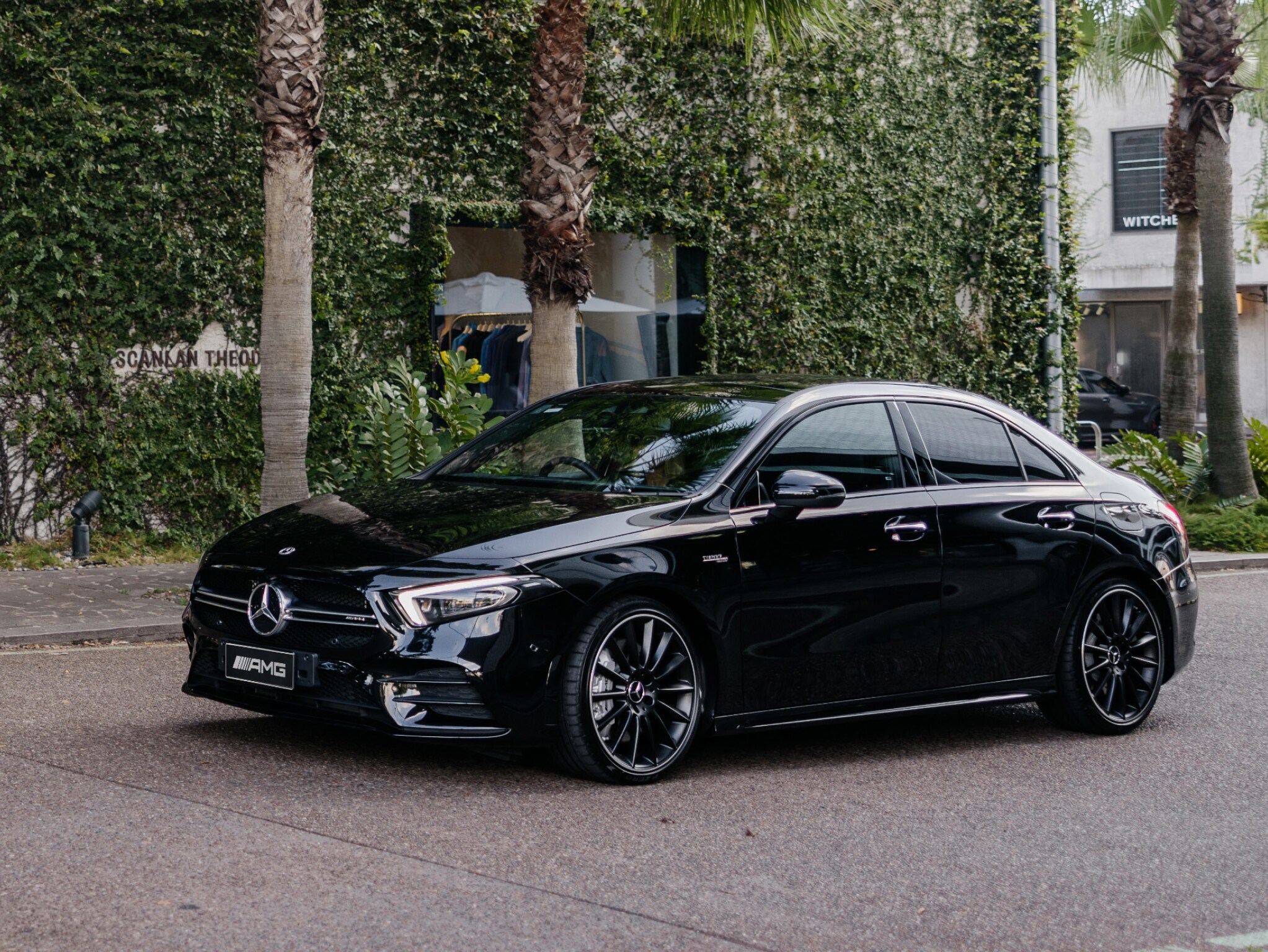 A black Mercedes-AMG A 35 4MATIC driving through a Brisbane laneway.