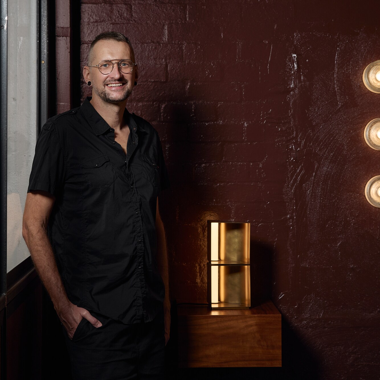 Volker Haug smiling next to own lighting design.