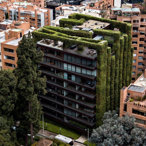 A cityscape with a green building at the centre