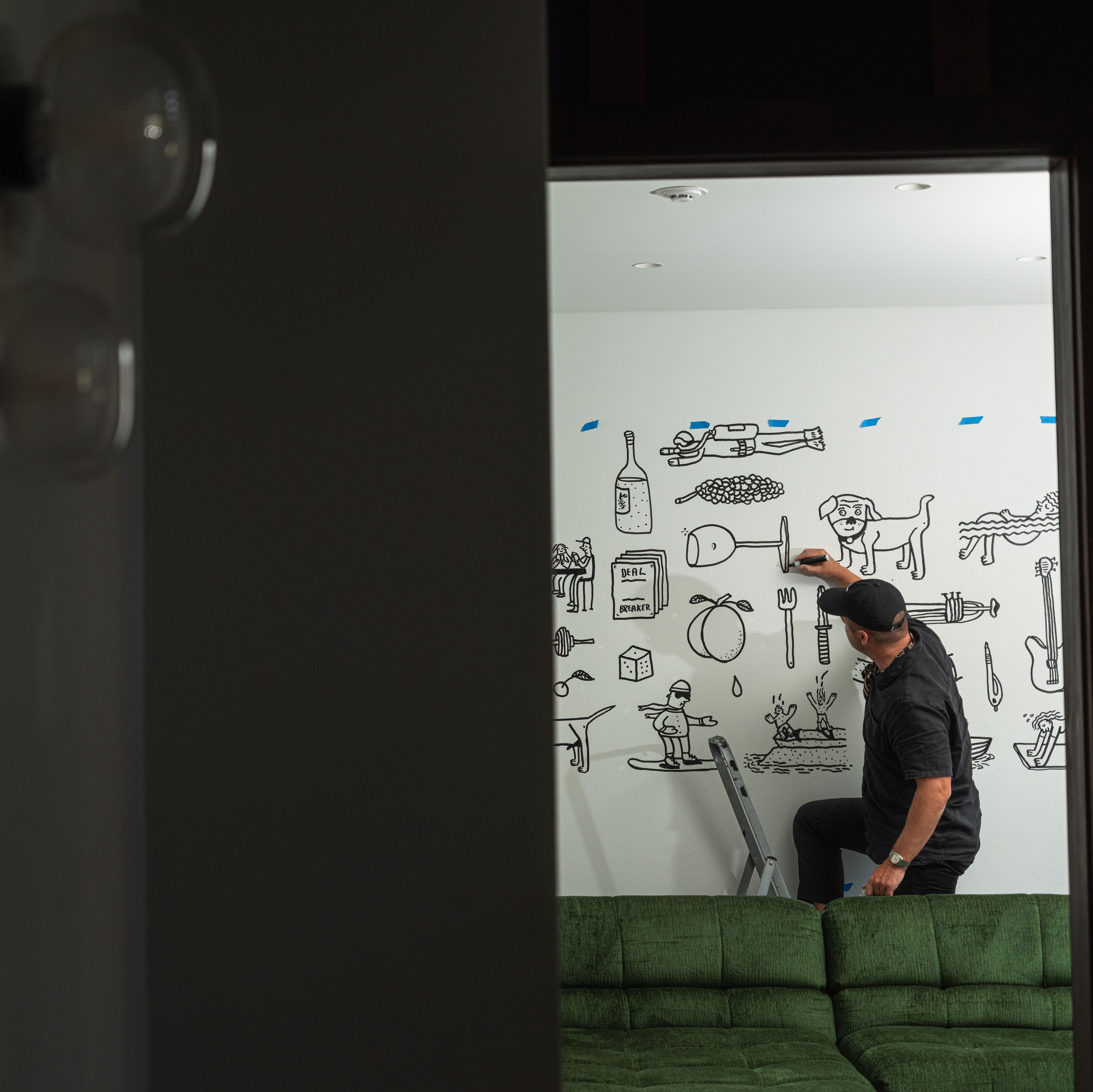 Artist Andrew J Steel drawing on a wall