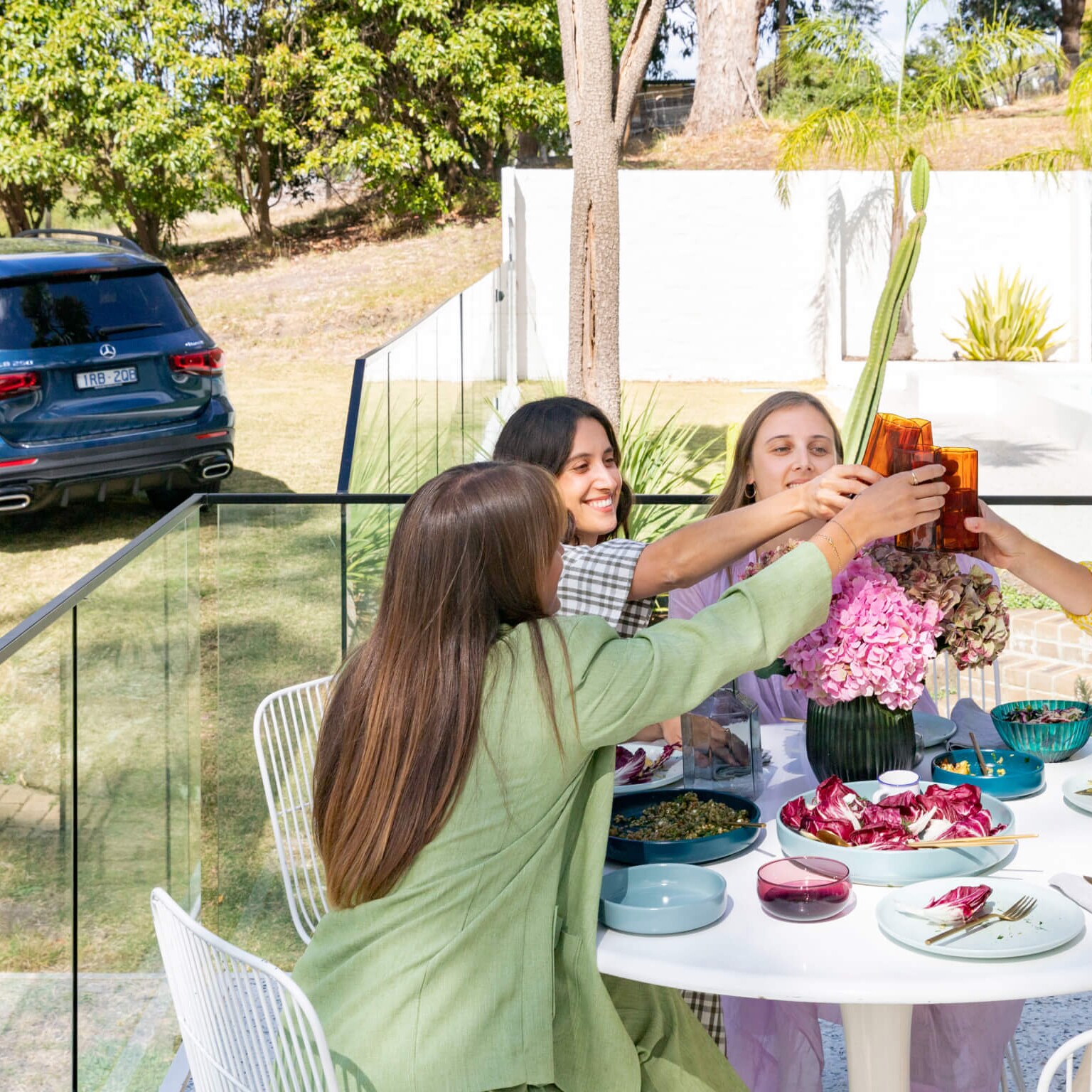 Lucy Feagins and friends sit at a table by the Fender House pool on the Mornington Peninsula.