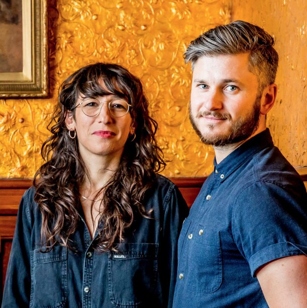 Georgia Nowak and Eugene Perepletchikov standing in front of a gold wall