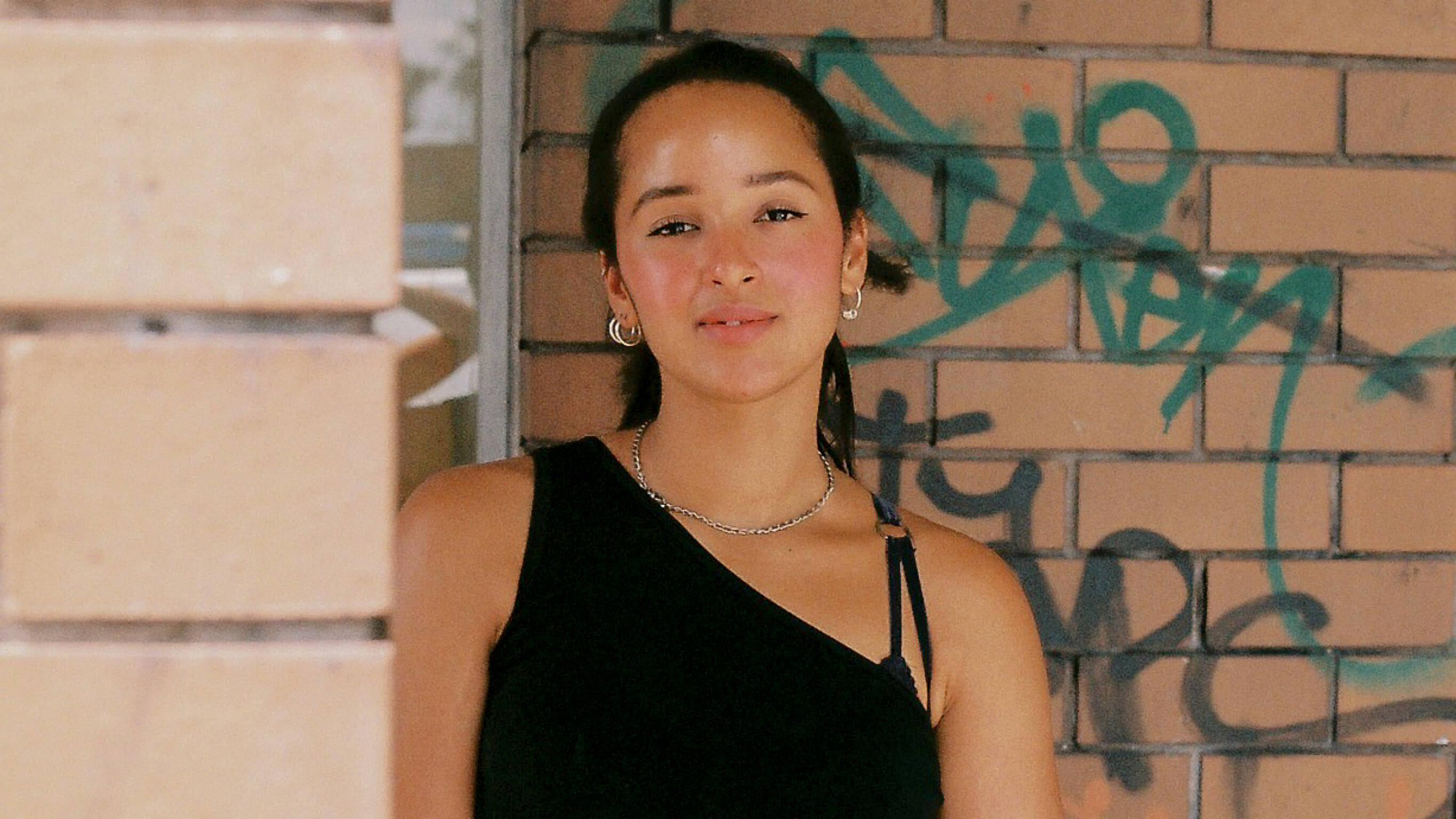 SabinaMcKenna Sabina McKenna stands in front of a brick wall with her hands held in front of her
