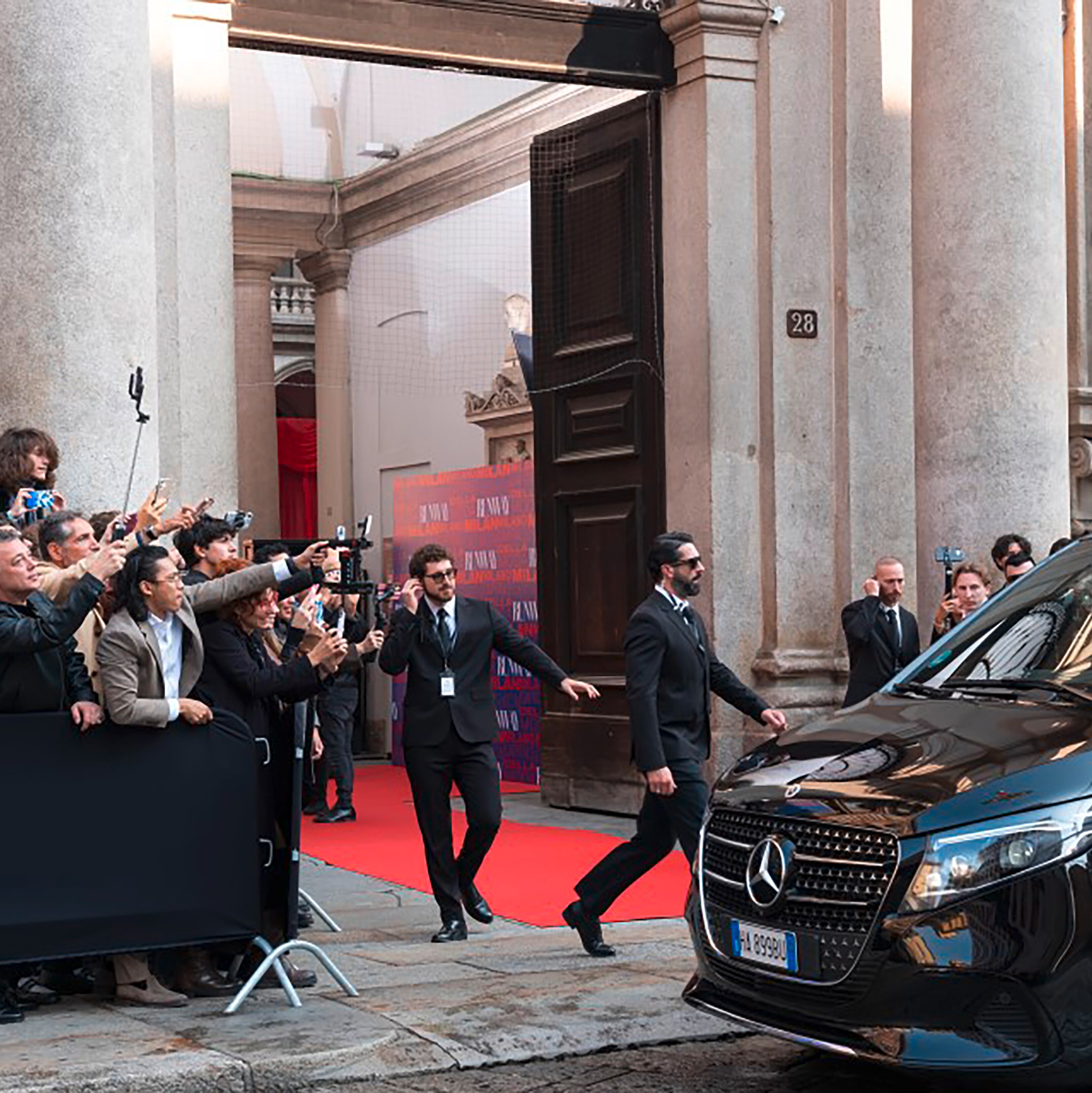 Paparazzi crowding by a car outside the entrance to a building. Image credit/photographer: Mercedes-Benz Group AG