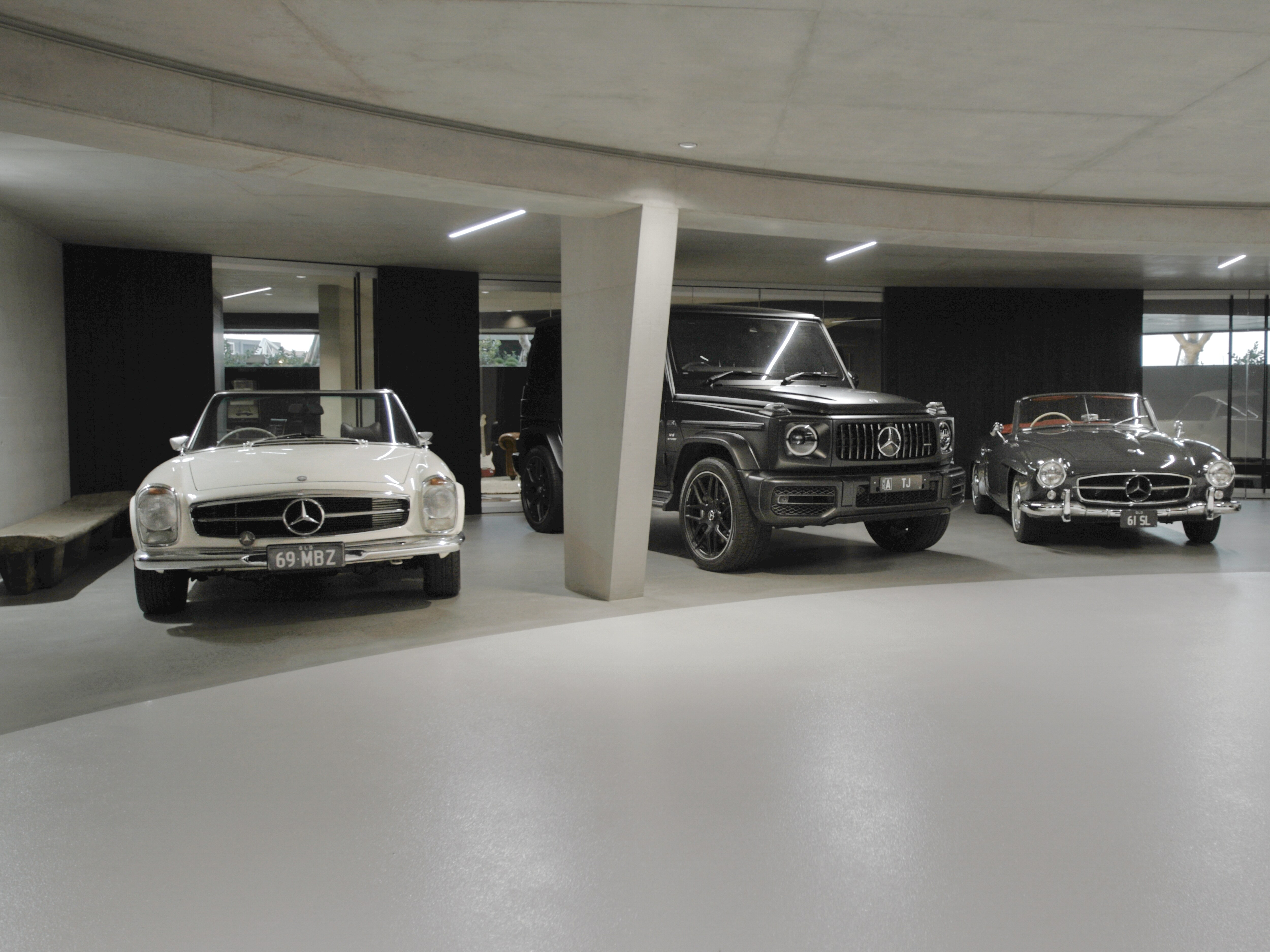Three Mercedes-Benz vehicles parked in a garage.