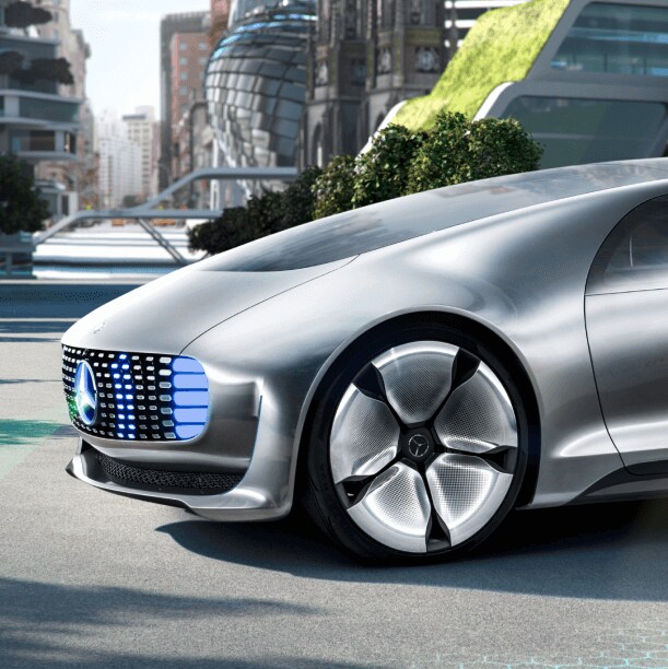 The Mercedes-Benz F 015 concept car projecting a pedestrian crossing on the road as a person walks in front of the car 