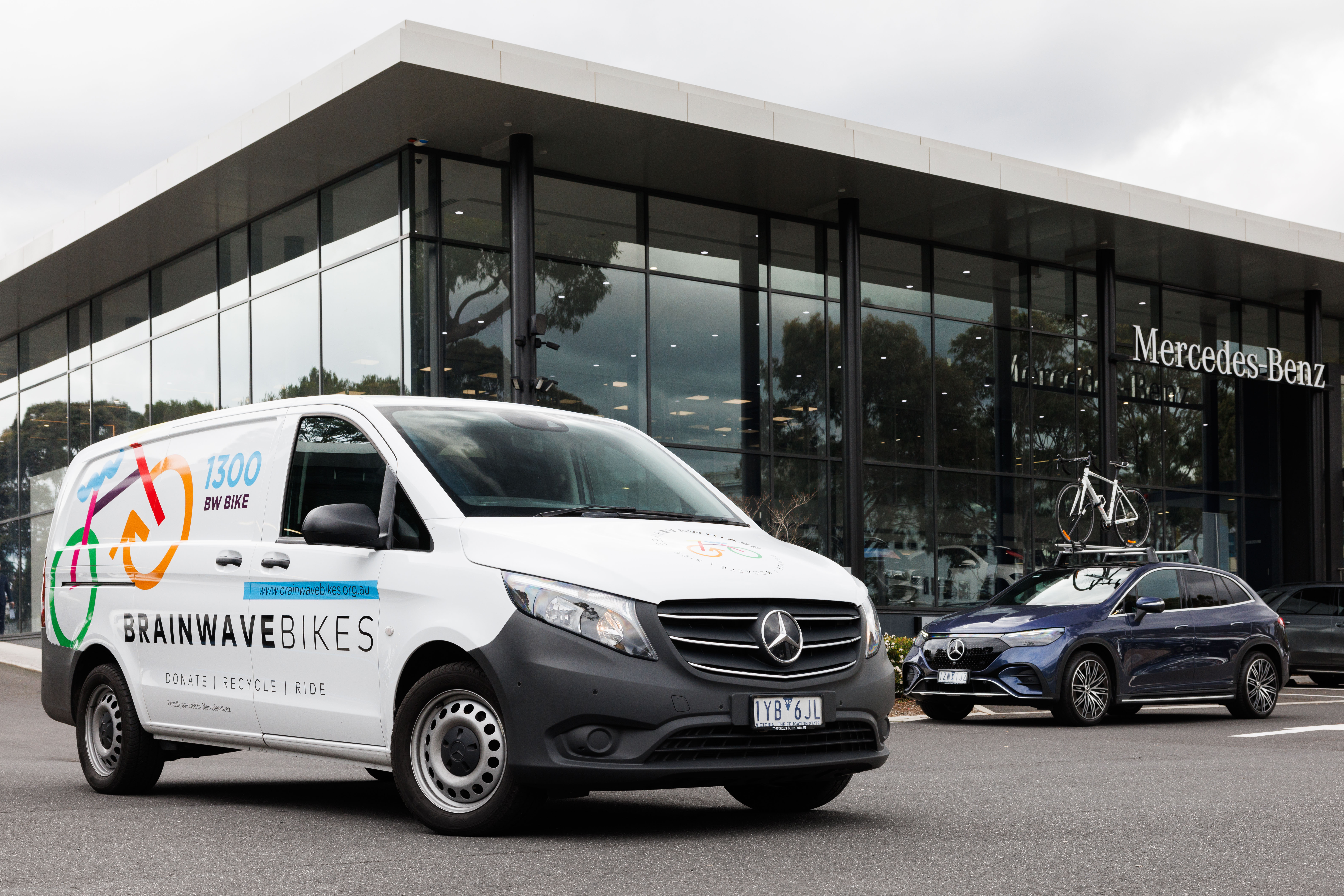 A Mercedes-Benz van and car parked outside a retailer. A Mercedes-Benz van and car parked outside a retailer.