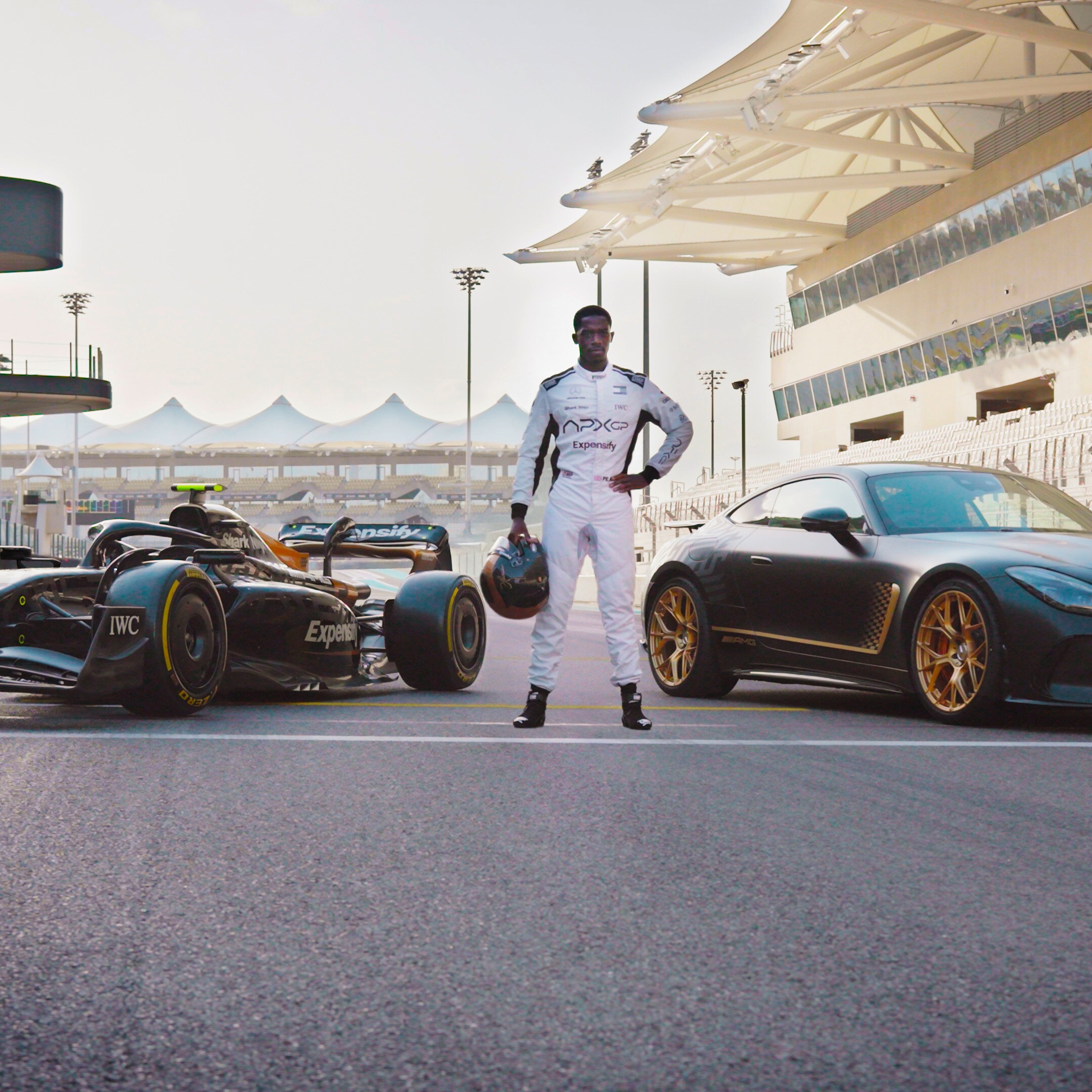 Damson Idris standing in front of two cars for F1: The Movie