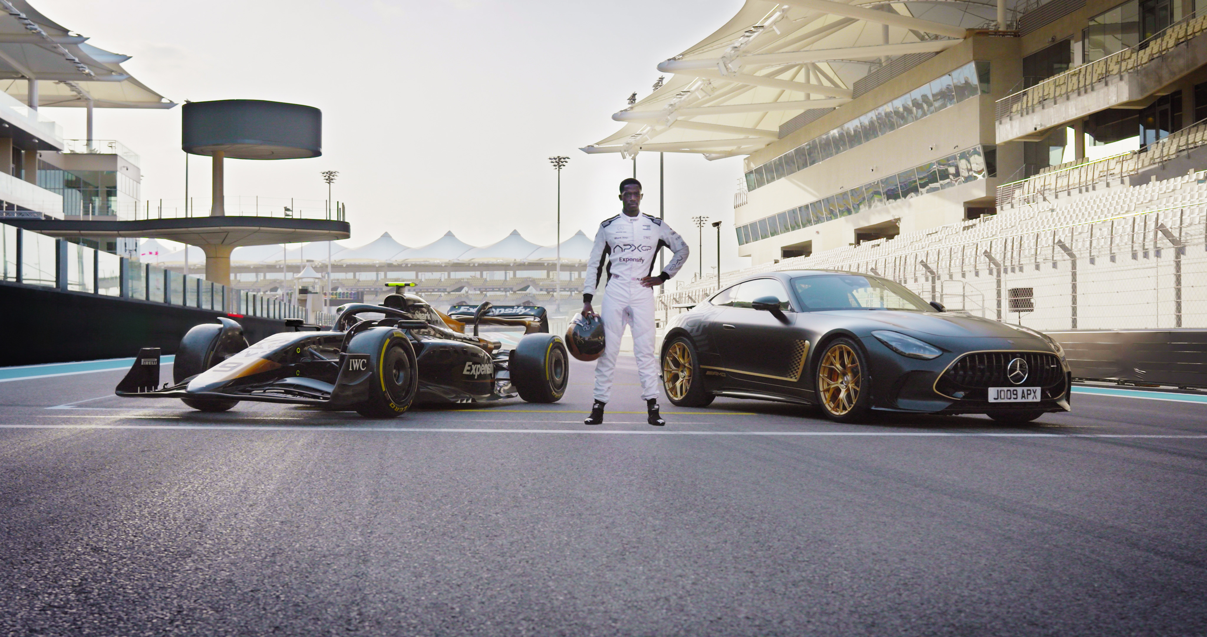 Damson Idris standing in front of two cars for F1: The Movie Damson Idris standing in front of two cars for F1: The Movie