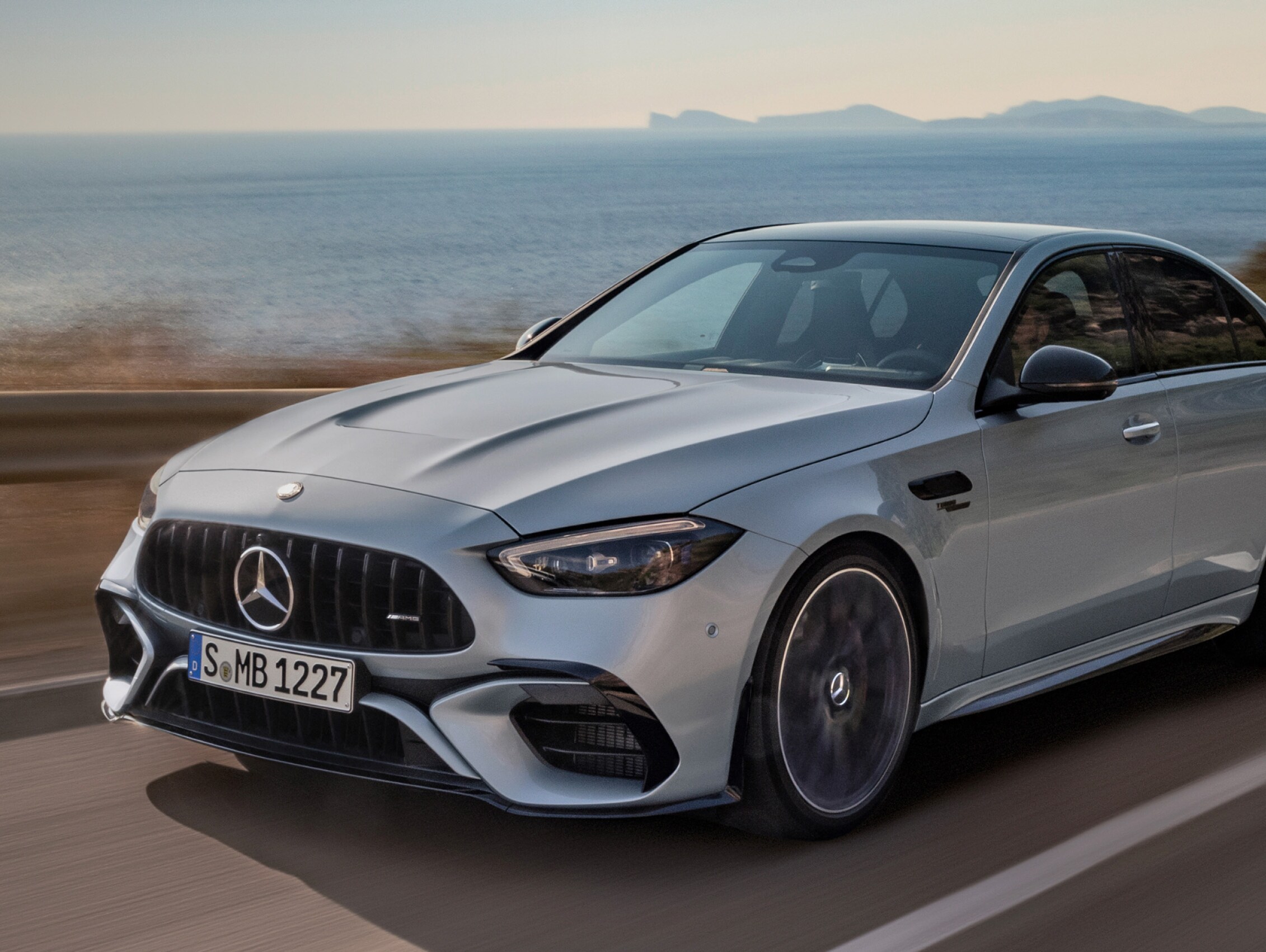Mercedes-AMG C 63 S E PERFORMANCE Sedan driving along coastal highway.