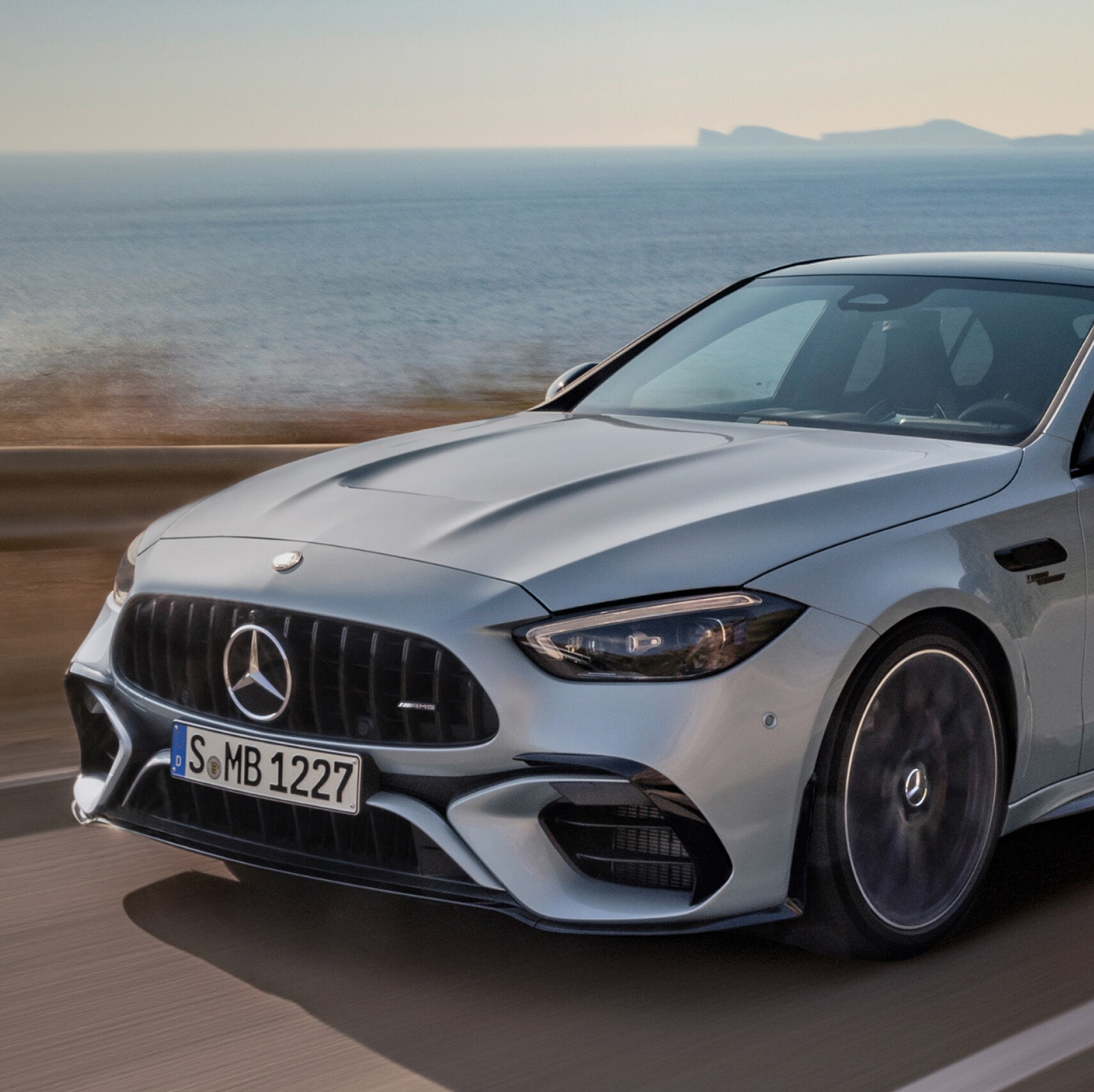 Mercedes-AMG C 63 S E PERFORMANCE Sedan driving along coastal highway.