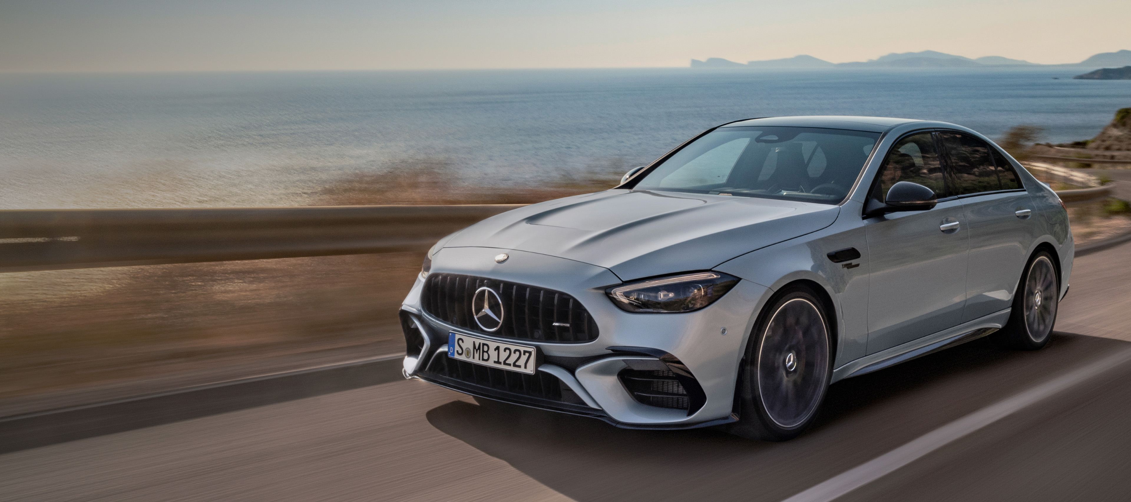 Mercedes-AMG C 63 S E PERFORMANCE Sedan Mercedes-AMG C 63 S E PERFORMANCE Sedan driving along coastal highway.