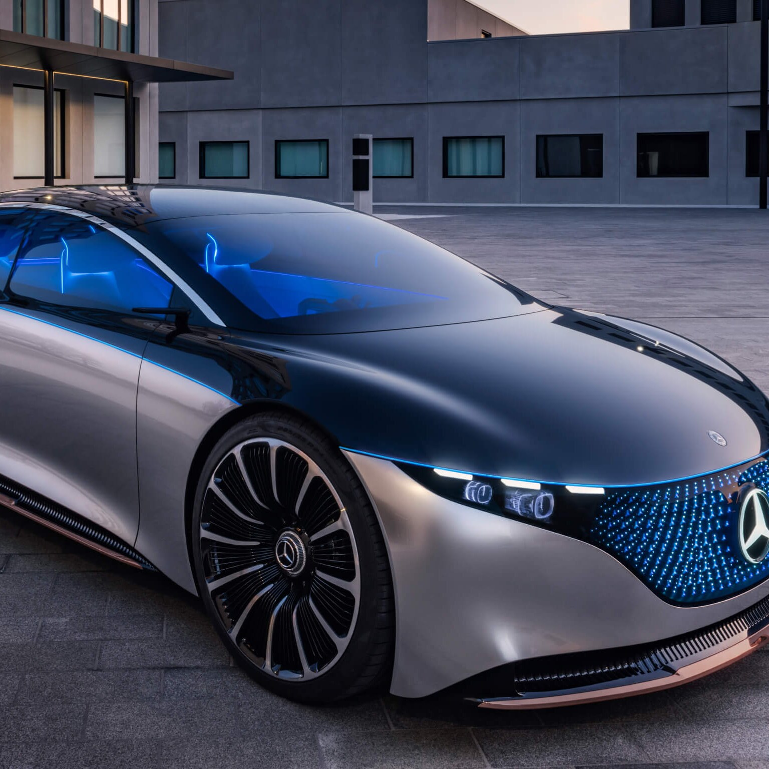 A luxurious blue and grey car in a courtyard