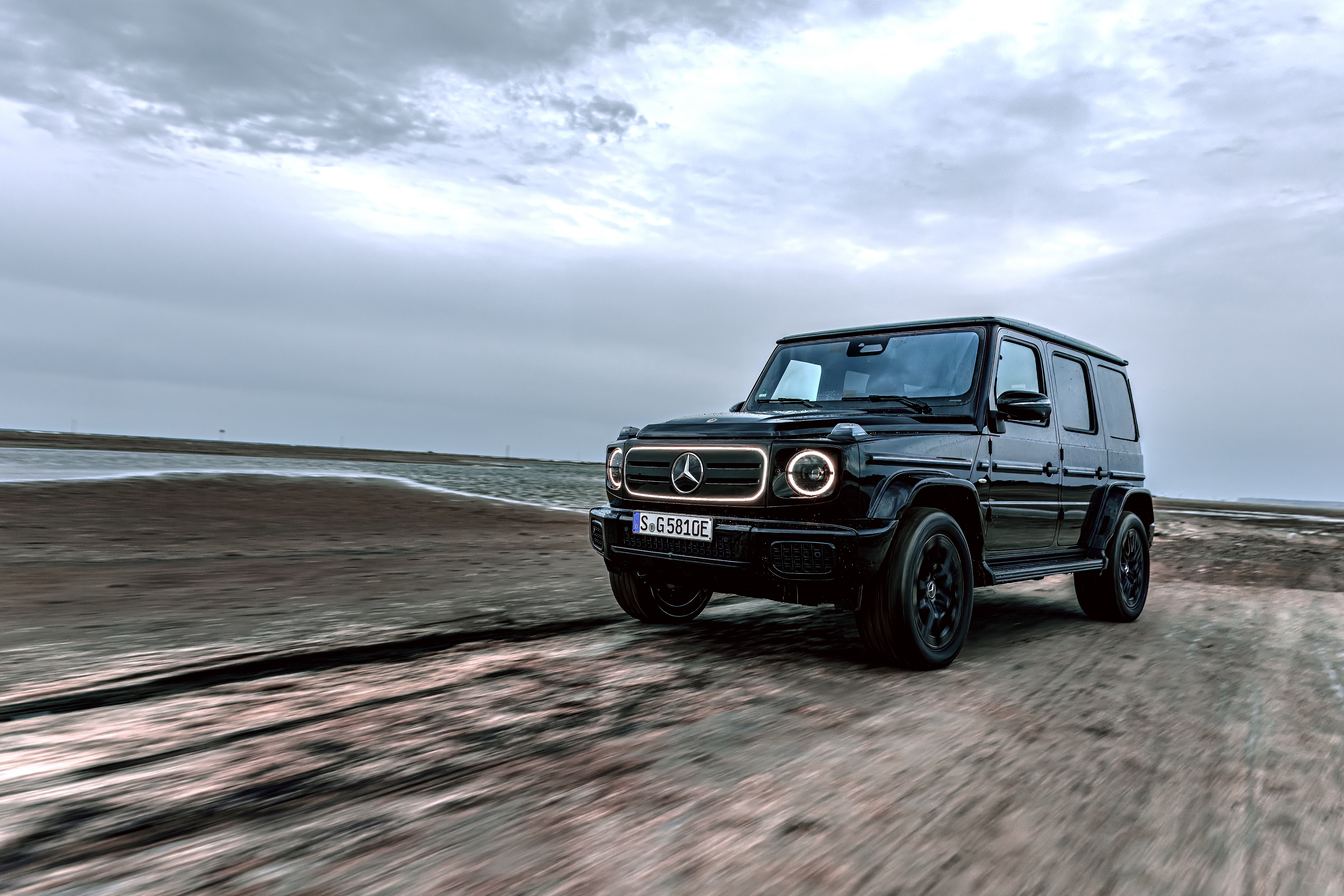Mercedes-Benz G-Class with EQ Technology driving on a dirt road Mercedes-Benz G-Class with EQ Technology driving on a dirt road