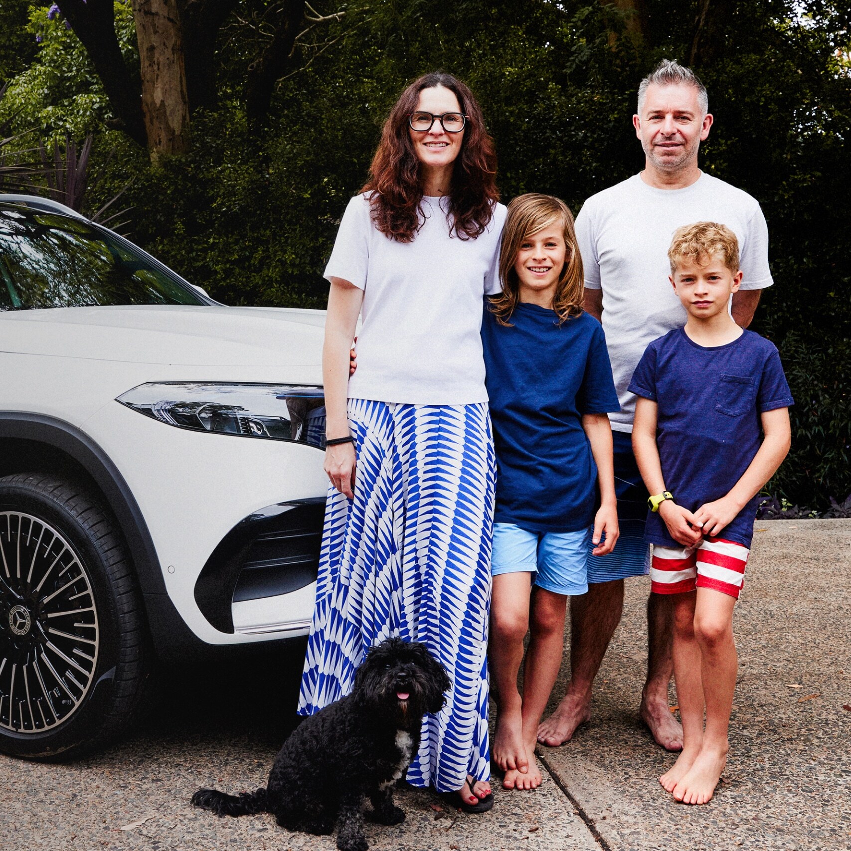 The Robinson family standing together in their driveway next to a white all-electric EQA. Image credit/photographer: Alisha Gore