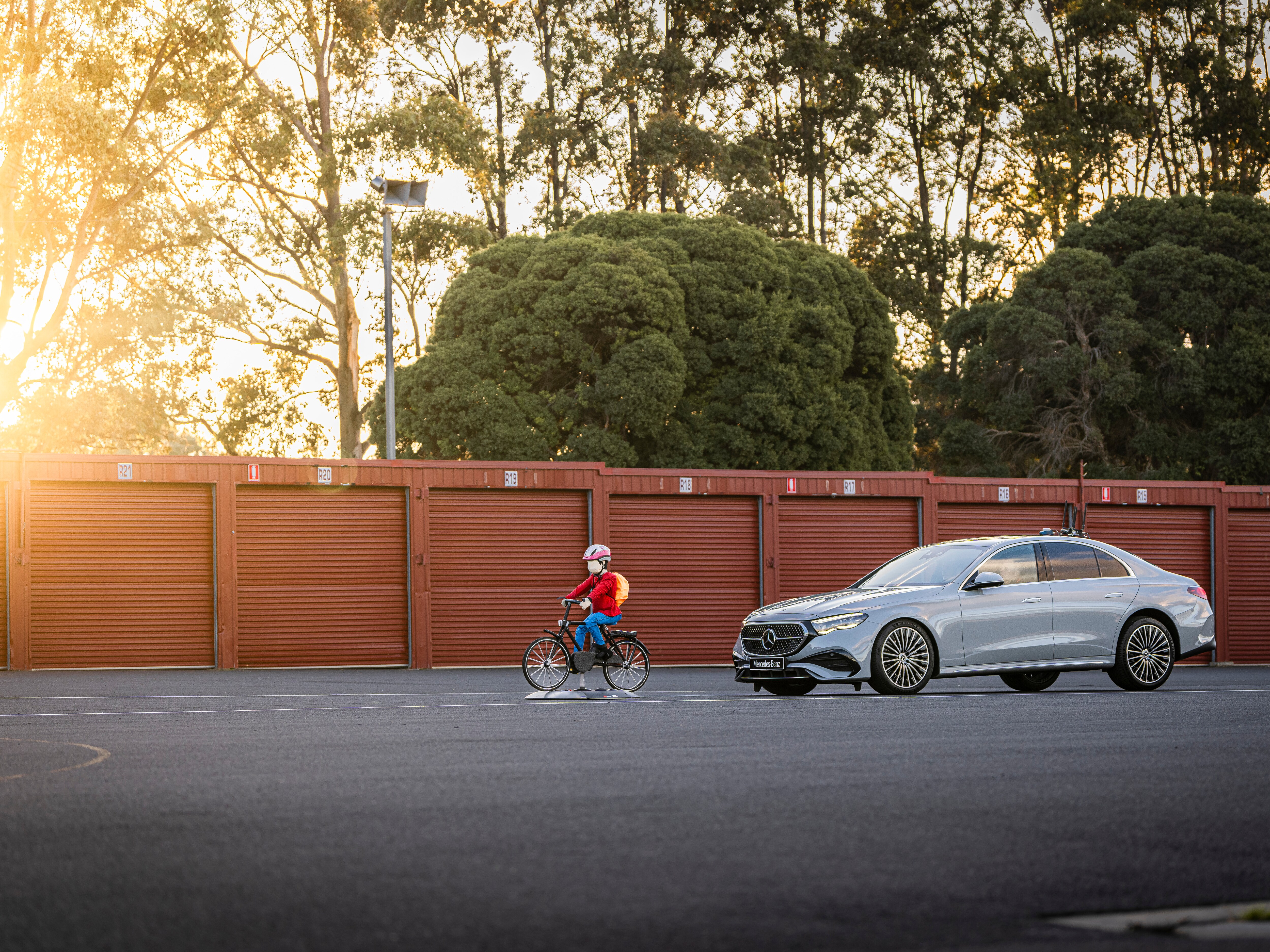  A crash-test dummy in front of a Mercedes-Benz E-Class Sedan. 