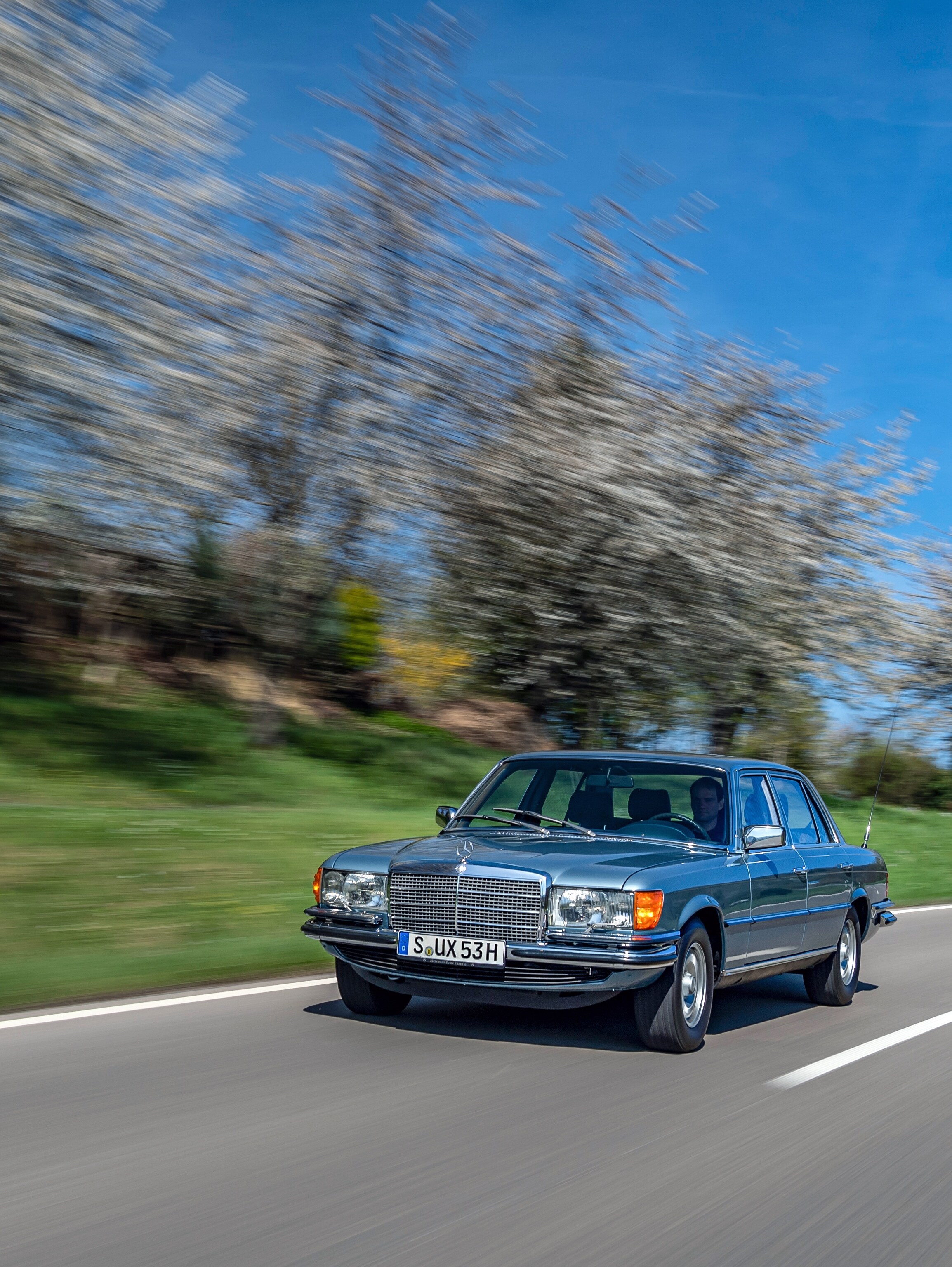 A blue classic Mercedes-Benz 450 SEL 6.9 on the road.