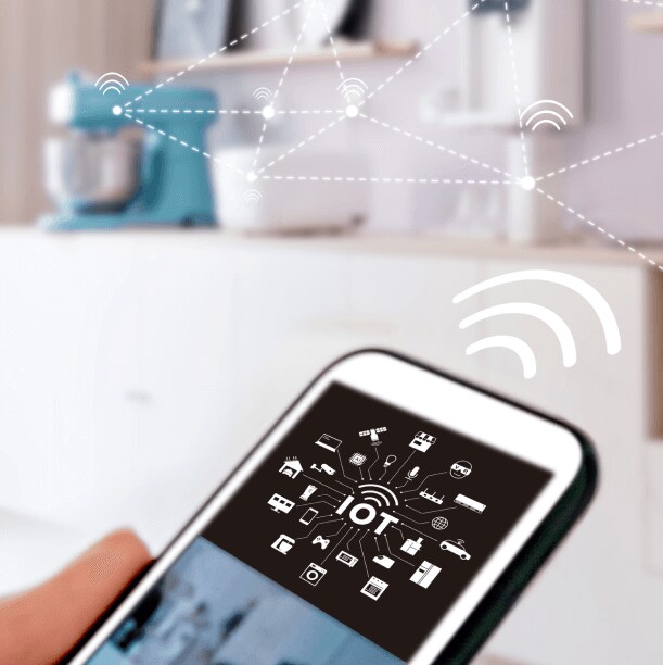 Someone holding a mobile phone to control smart devices in their kitchen
