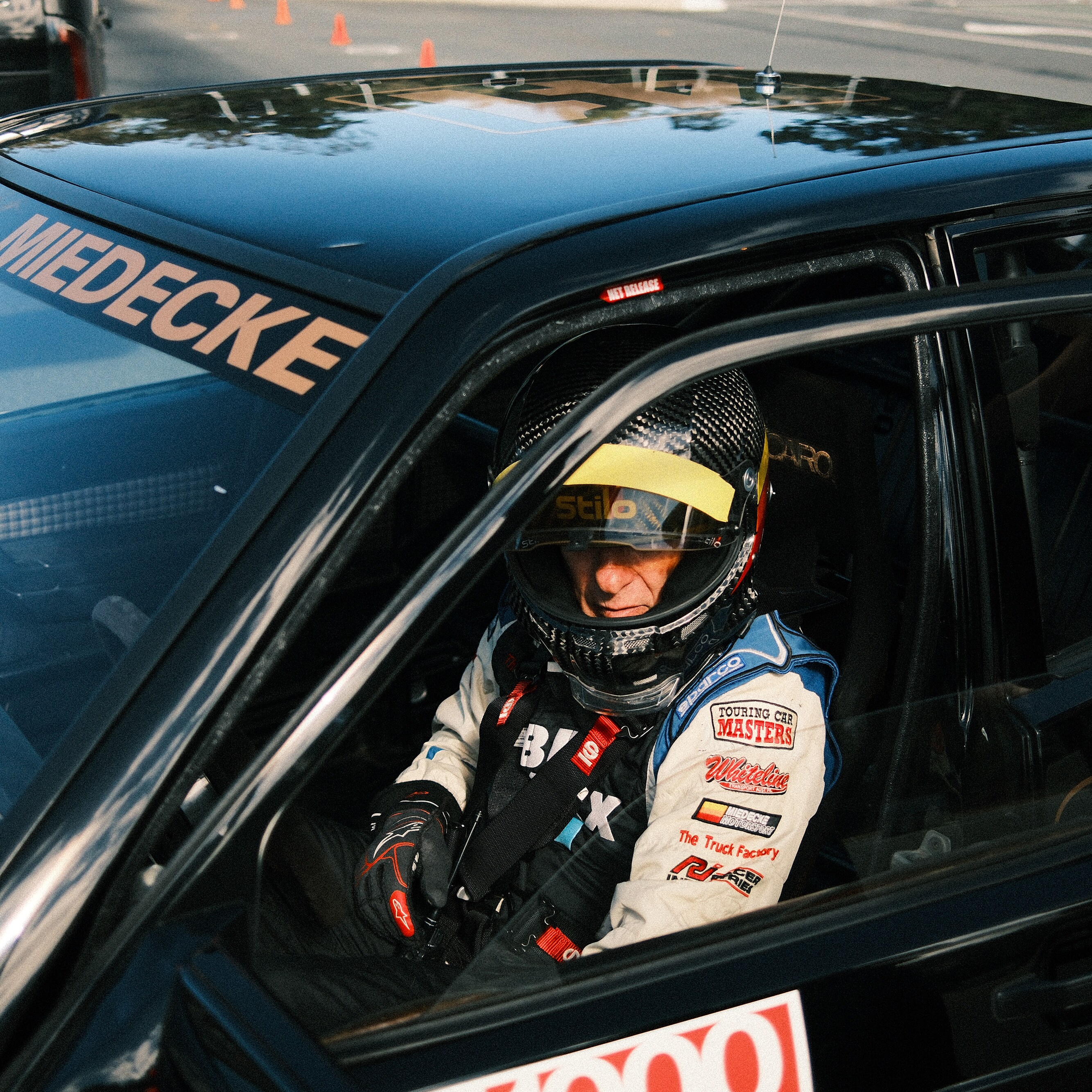 Andrew Miedecke standing inside his restored Mercedes-Benz 190 E 2.3-16 race car
