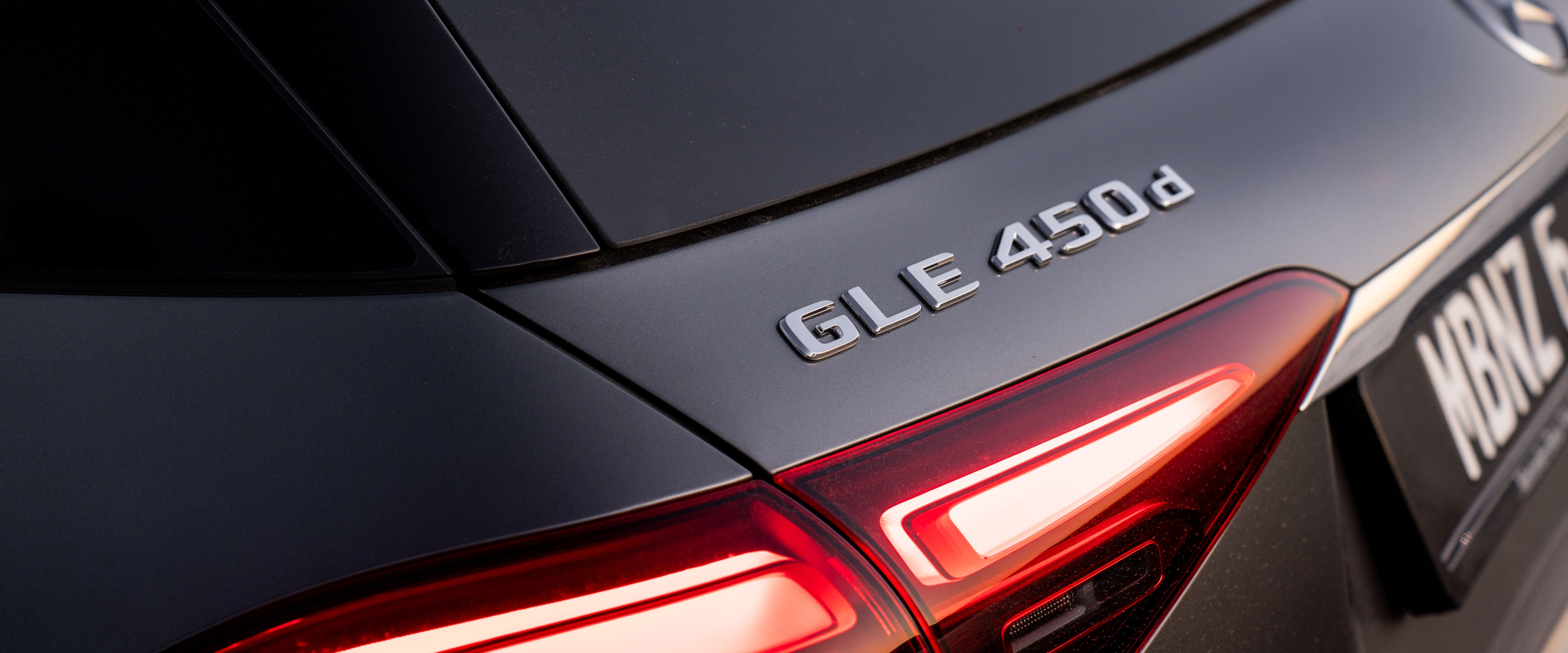 A close-up of the badge of a Mercedes-Benz GLE 450 d.