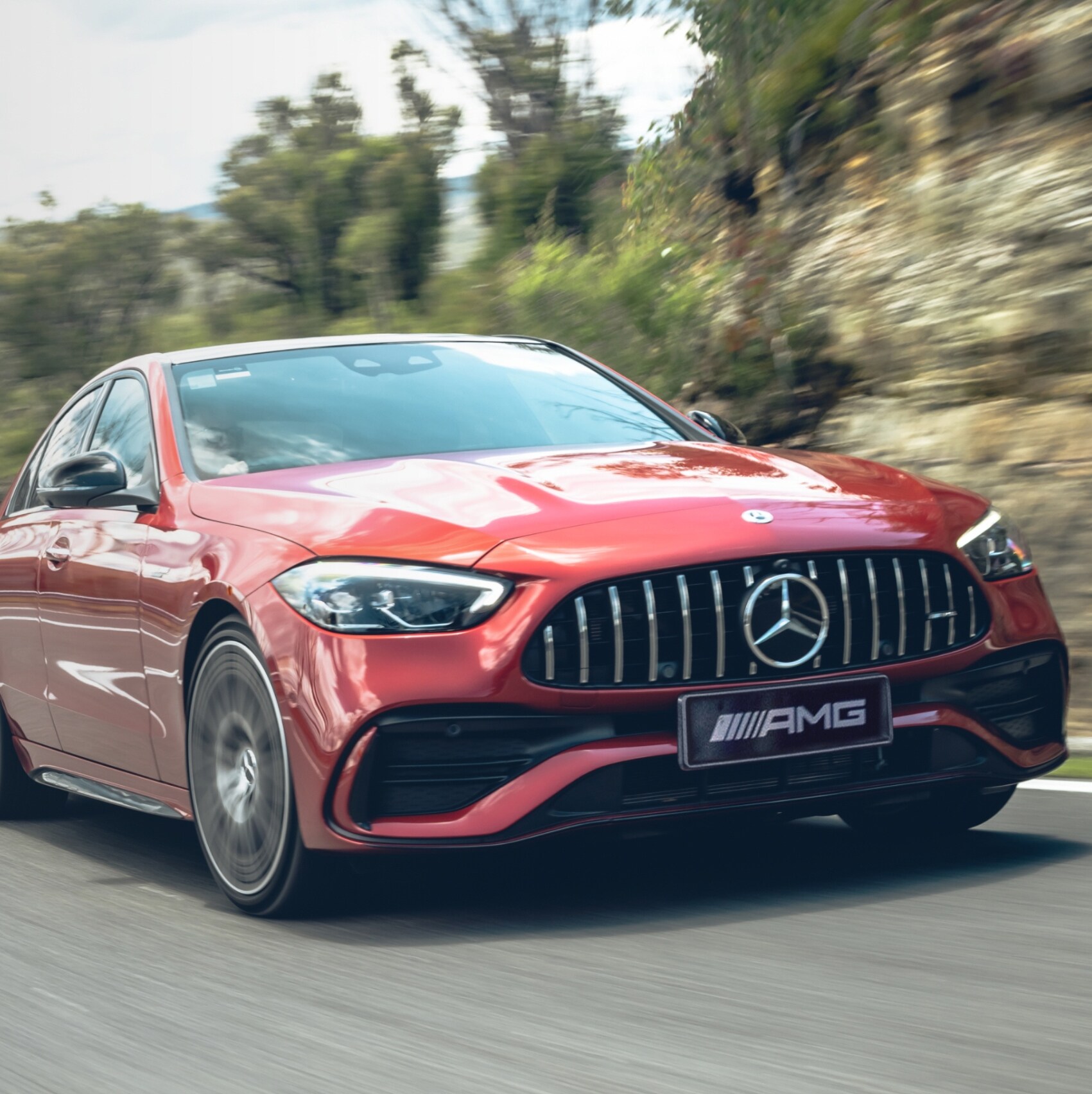 A red Mercedes-AMG C 43 driving round a bend in the road.
