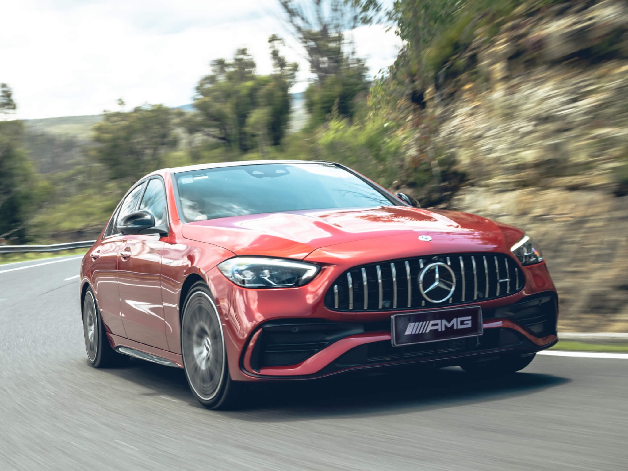 A red Mercedes-AMG C 43 driving round a bend in the road.