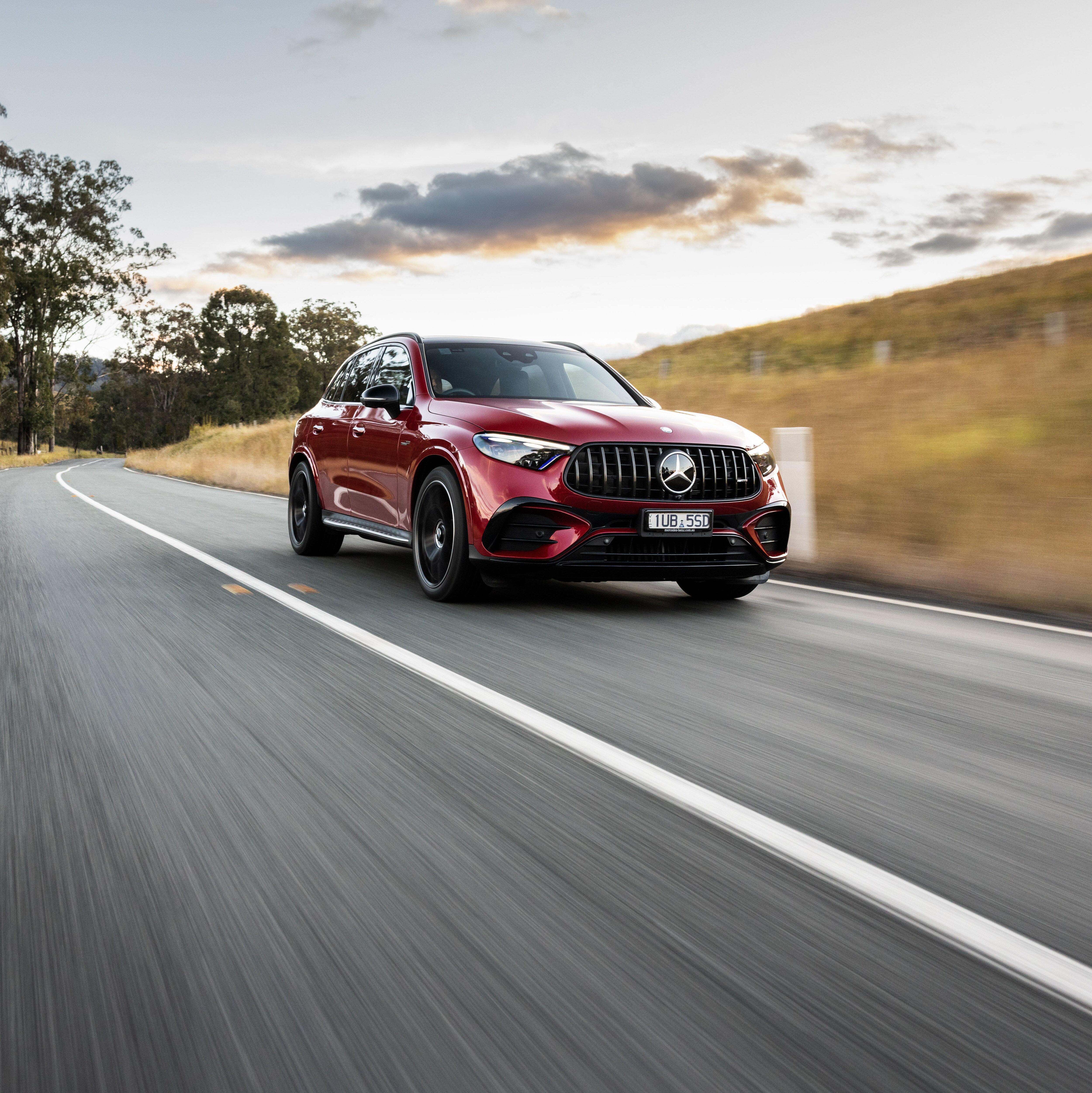 Red Mercedes-AMG C 63 S E PERFORMANCE driving on the road.