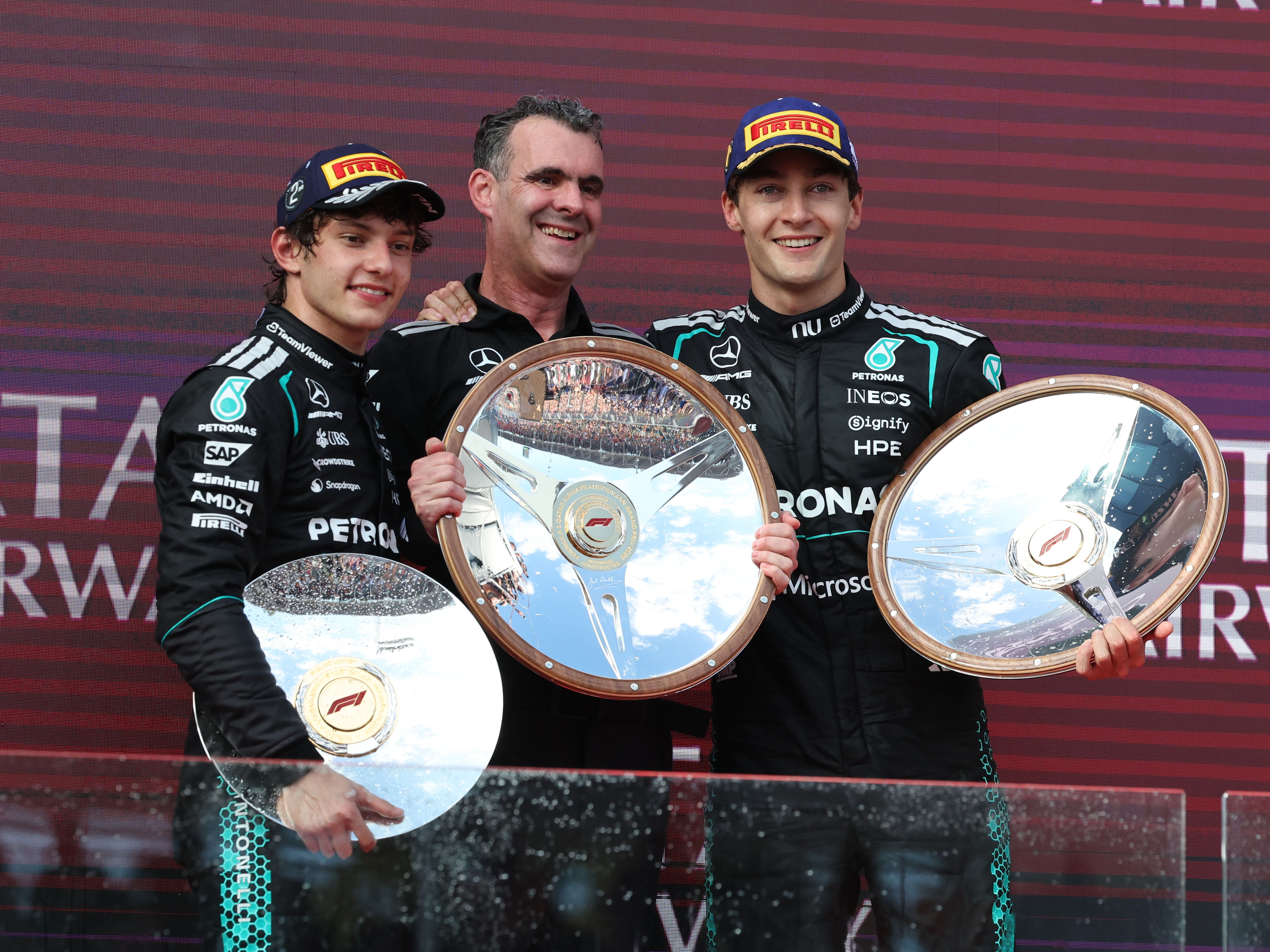 George Russell and Kimi Antonelli smiling and holding trophies at the 2026 Australian Grand Prix.