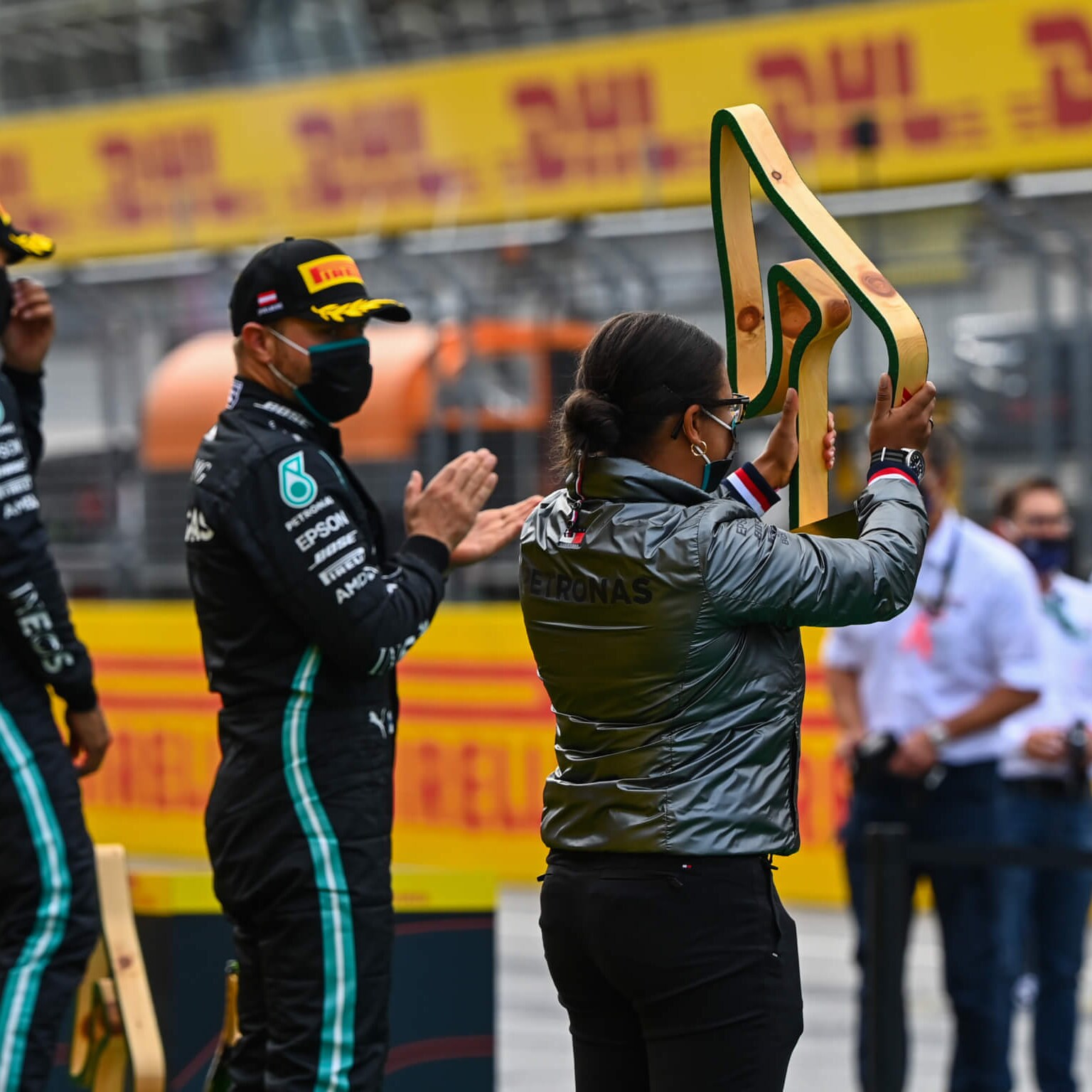 Stephanie Travers holds up trophy atop the F1 podium