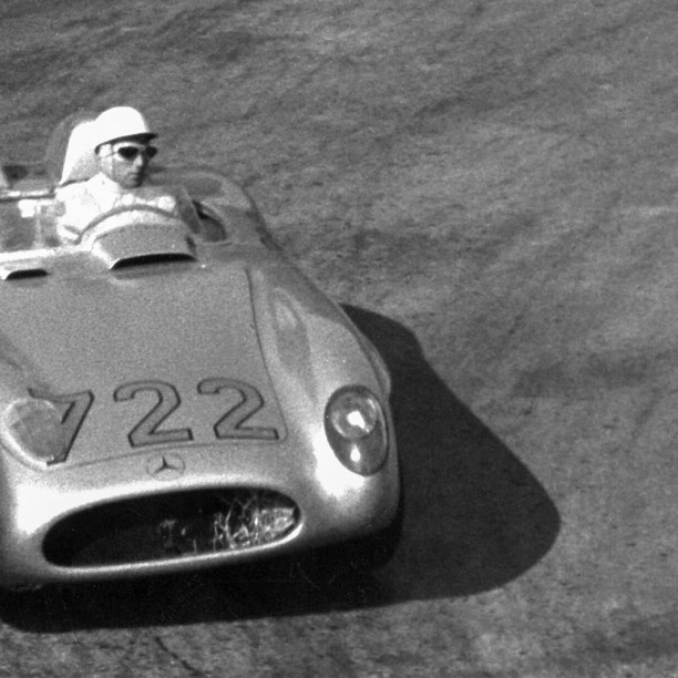 A black and white photo of two men in a Mercedes-Benz 300 SLR in 1955