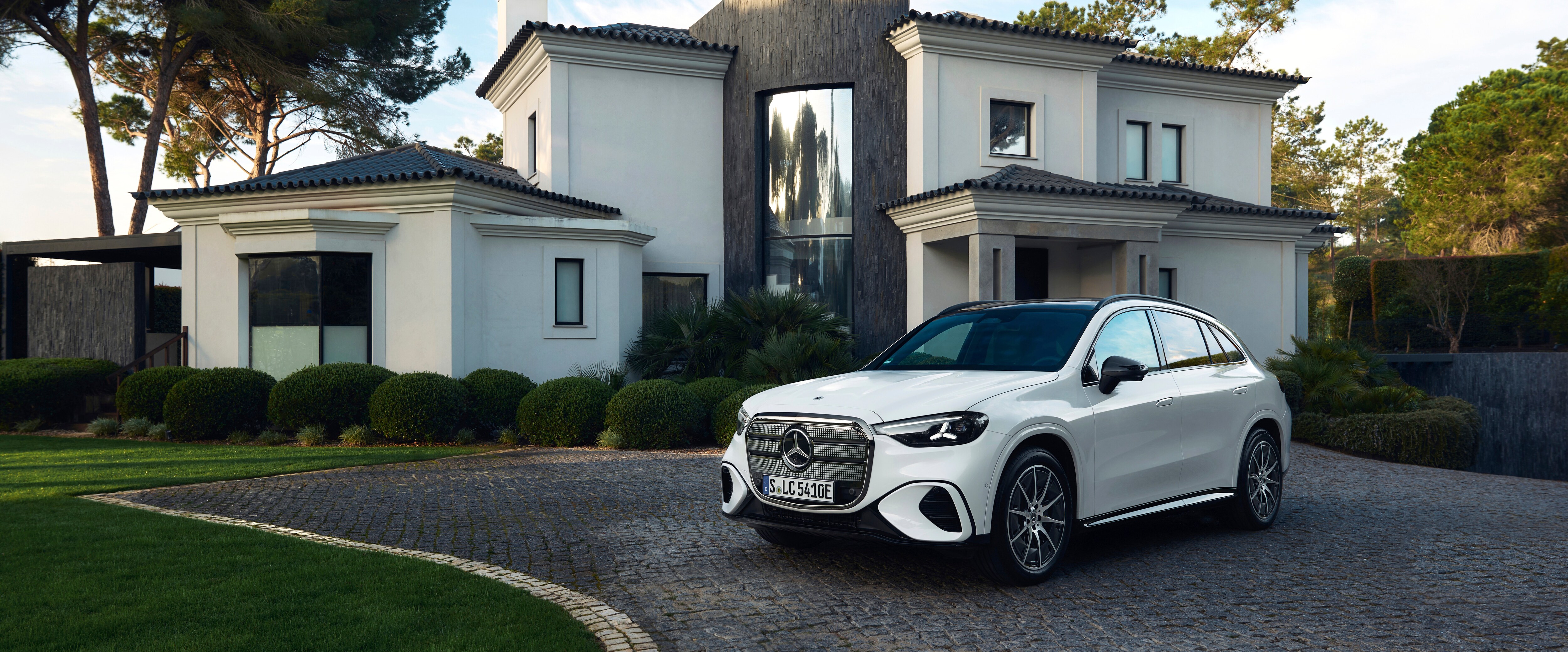 A white SUV parked in the driveway of a house