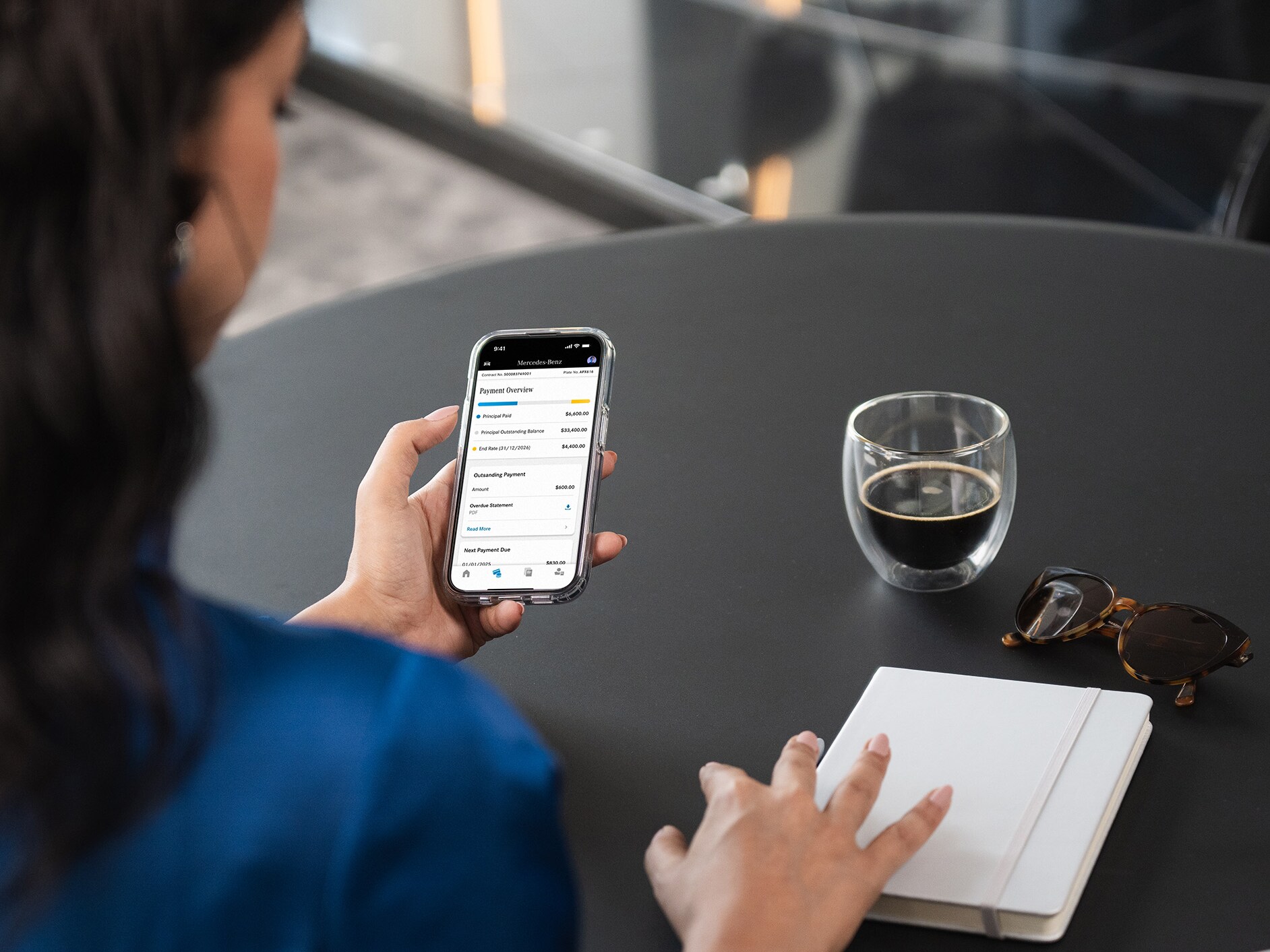 A person on their phone using the Mercedes-Benz Finance App.
