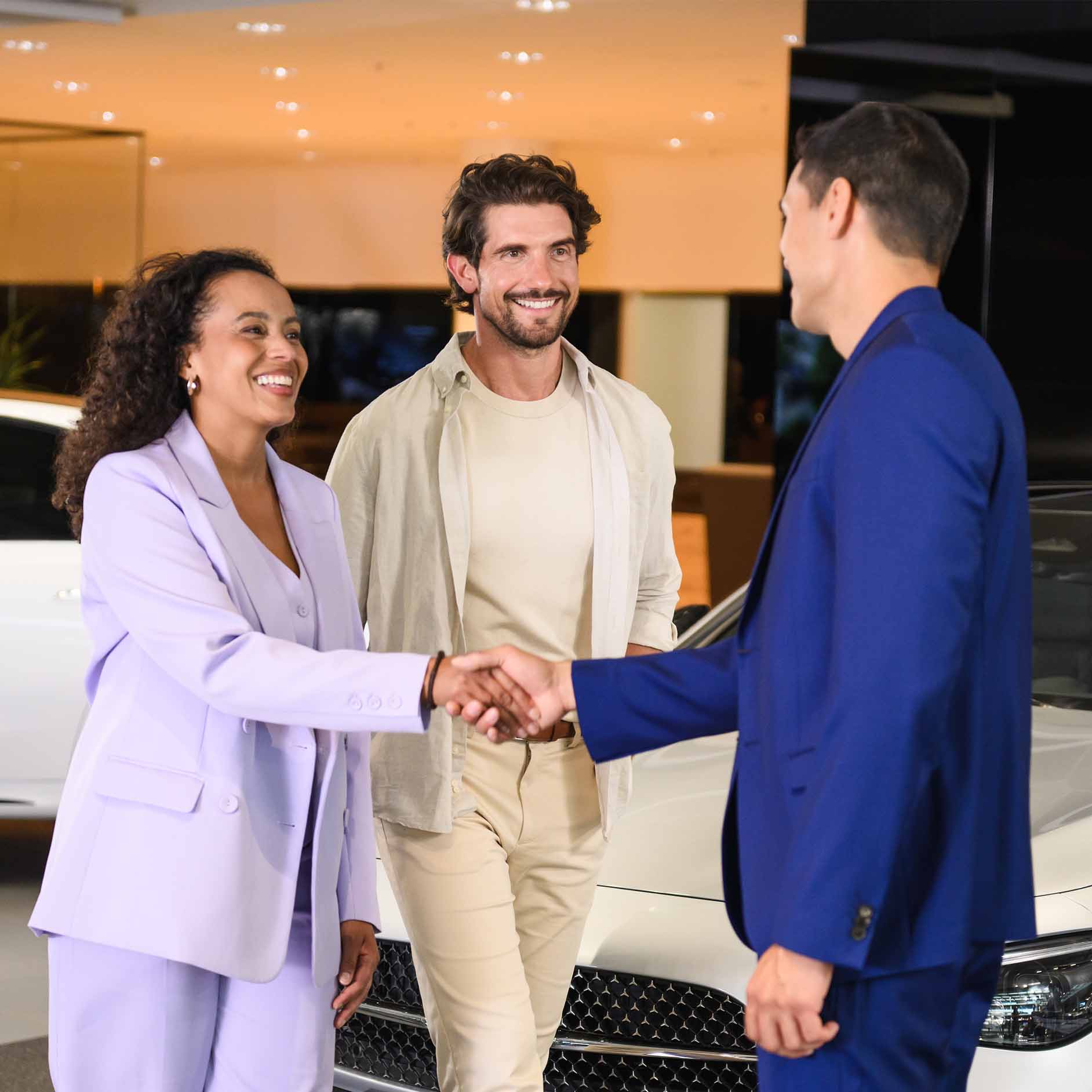 Speak to an expert A couple speaking to a business manager in a dealership.