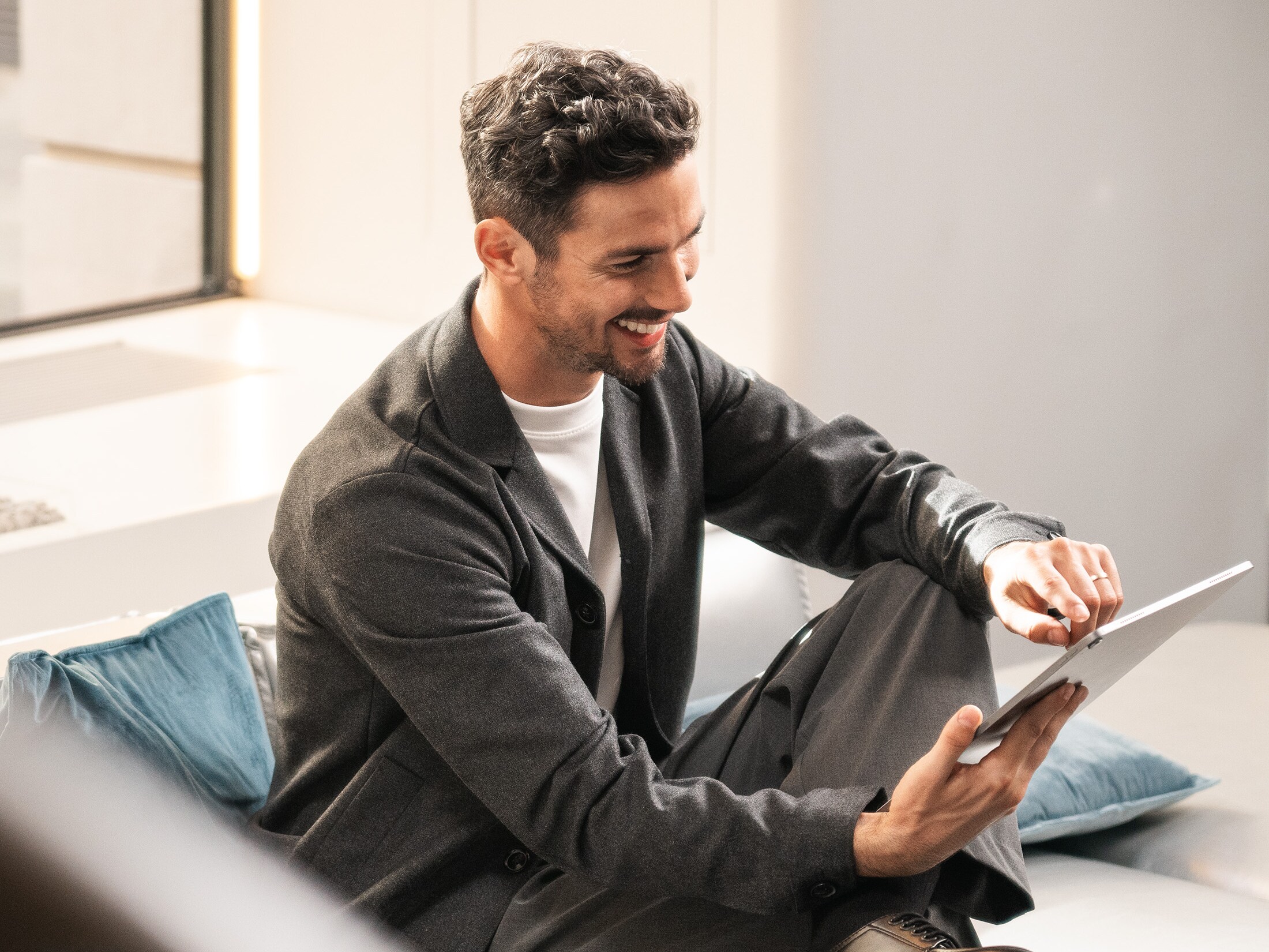 A person sitting in a chair holding a mobile device.