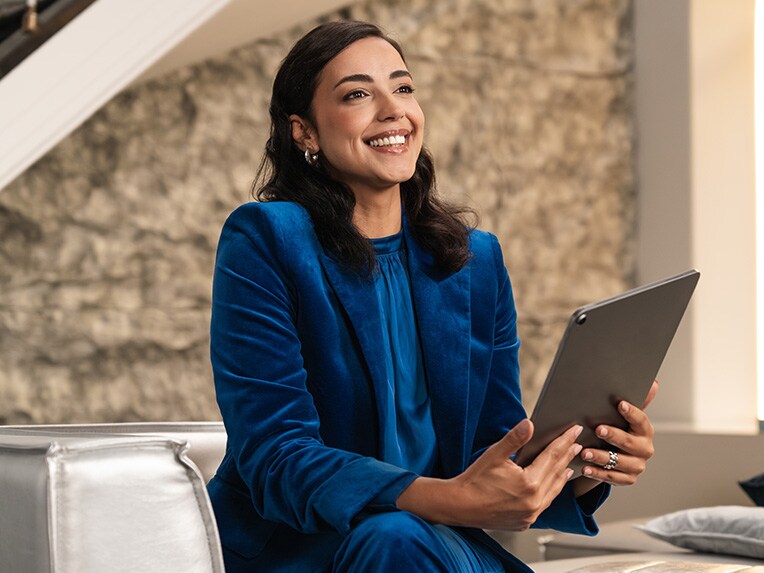 A person sitting in a chair looking at a mobile device.
