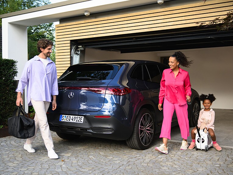 Two people and a child going to their Mercedes-Benz vehicle.