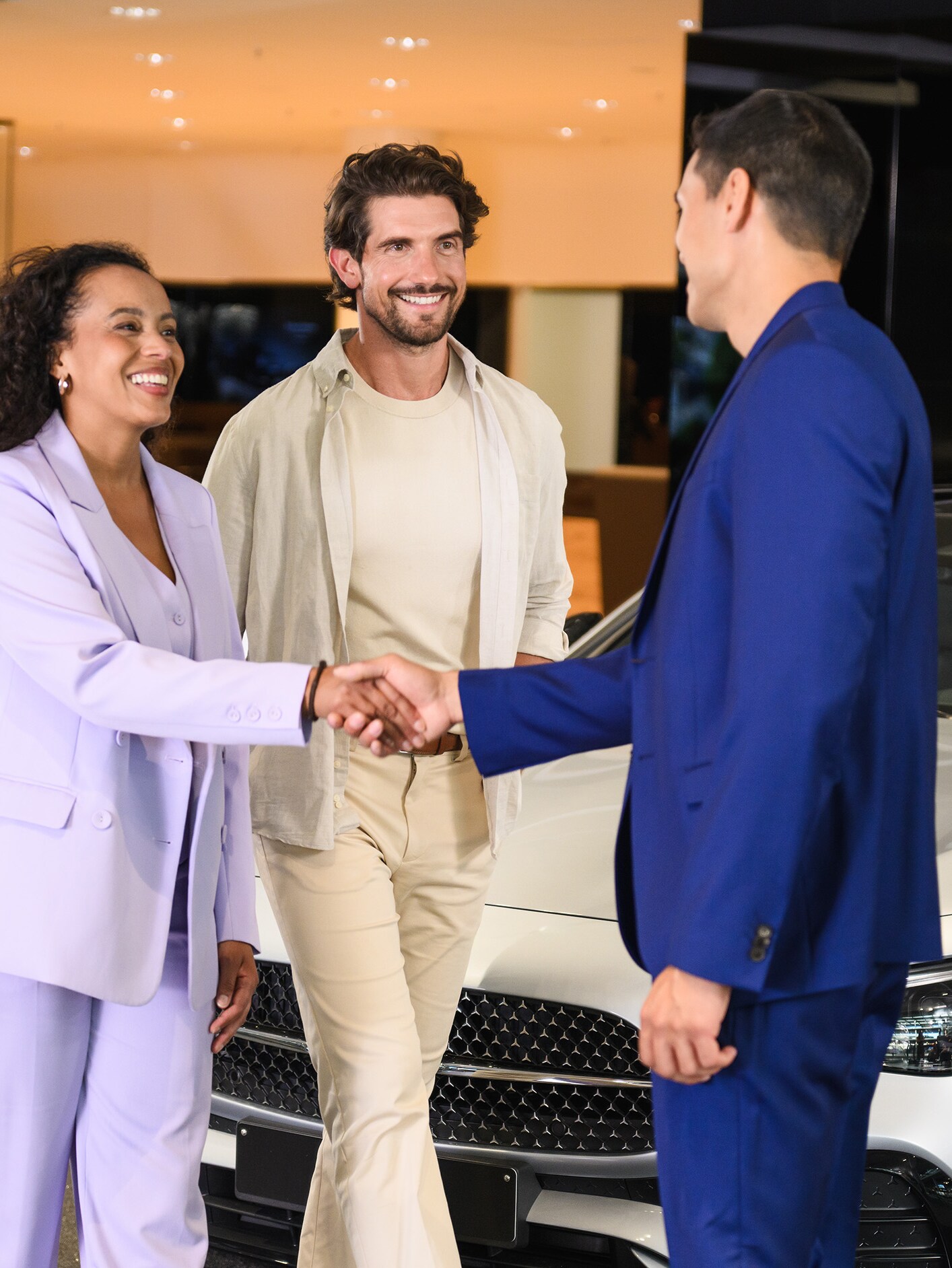 A couple in a Mercedes-Benz showroom speaking to a Business Manager.