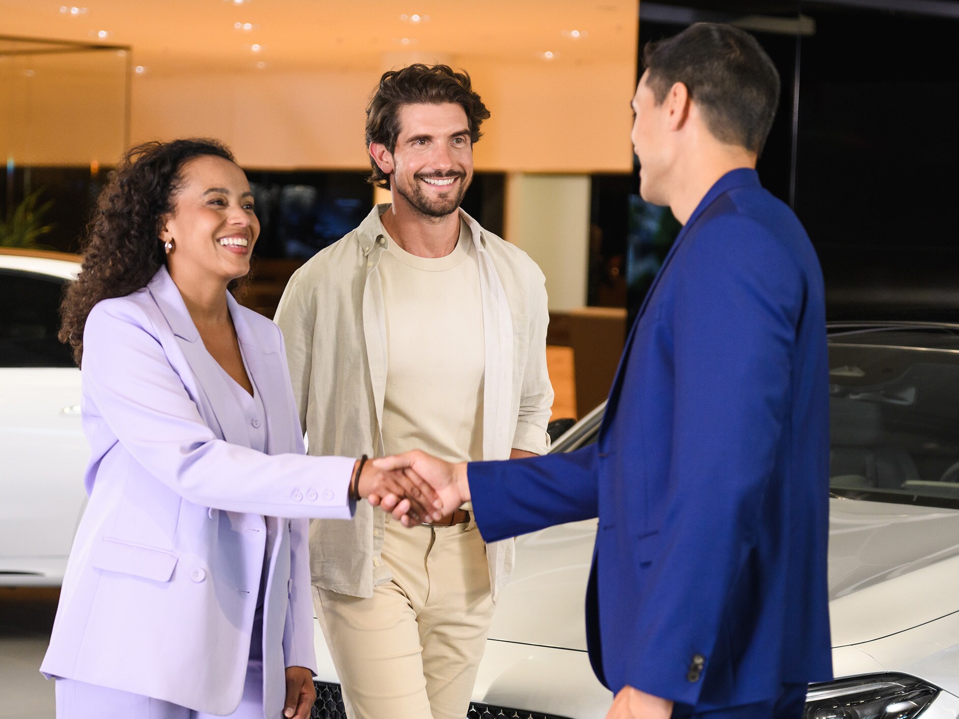 A couple in a Mercedes-Benz showroom speaking to a Business Manager.