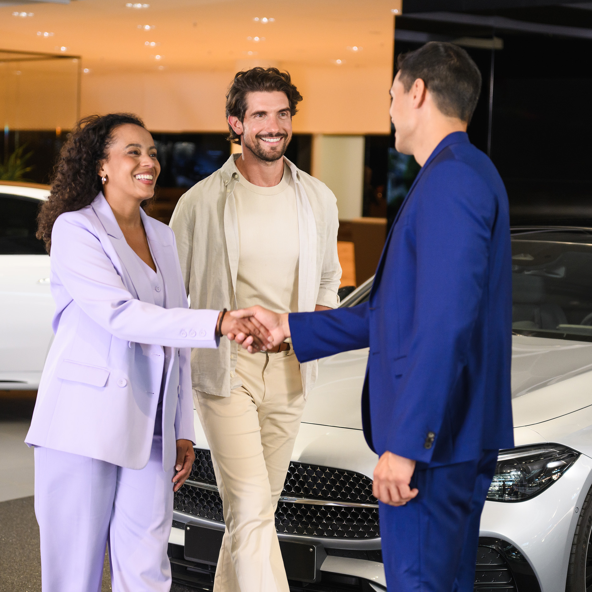 Insurance cover | Telematics-based car insurance A couple in a Mercedes-Benz showroom speaking to a Business Manager.