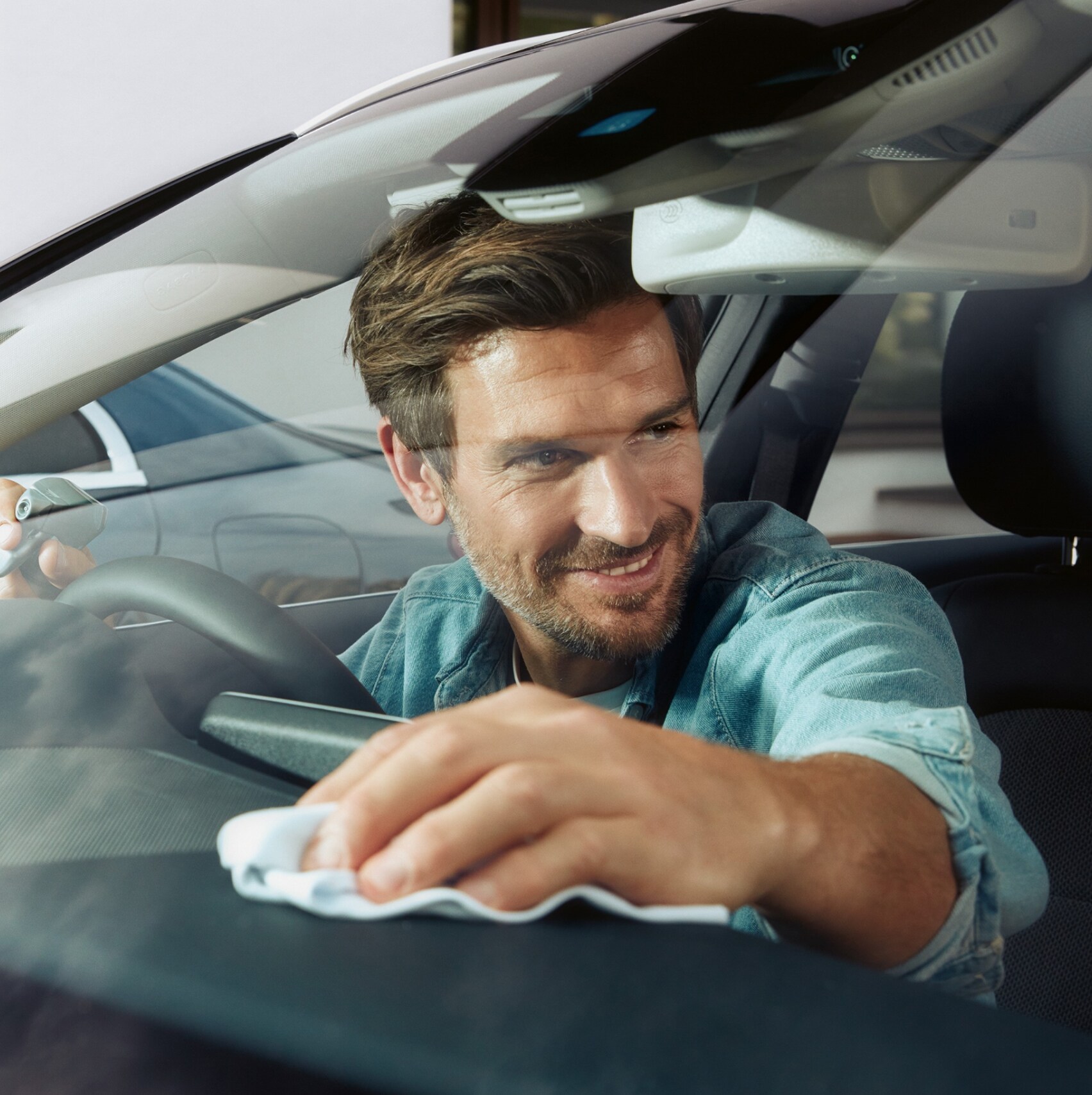 A man cleaning the interior of his Mercedes-Benz