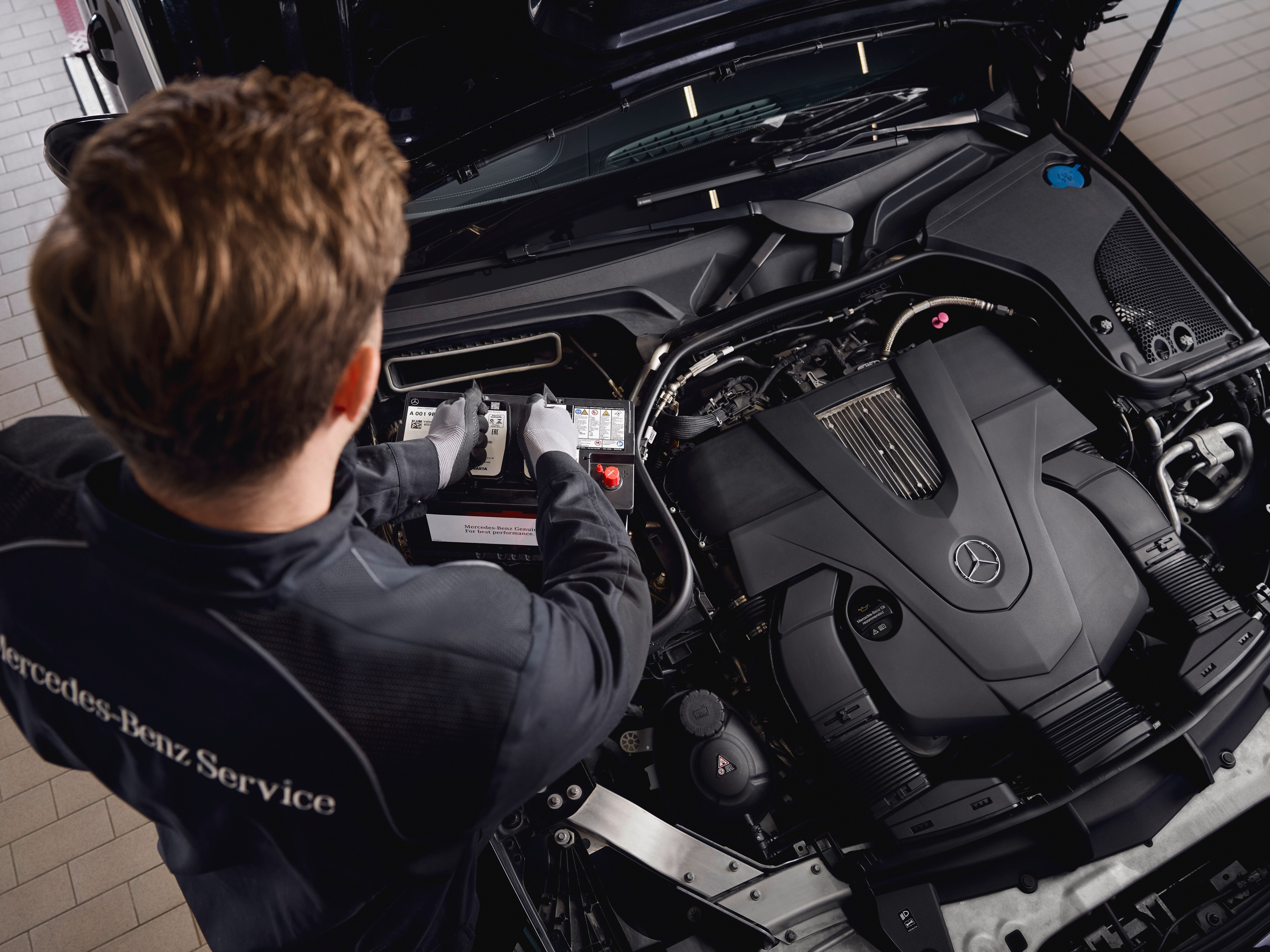 Engine service at a workshop, showing the replacement of components using genuine Mercedes‑Benz parts.