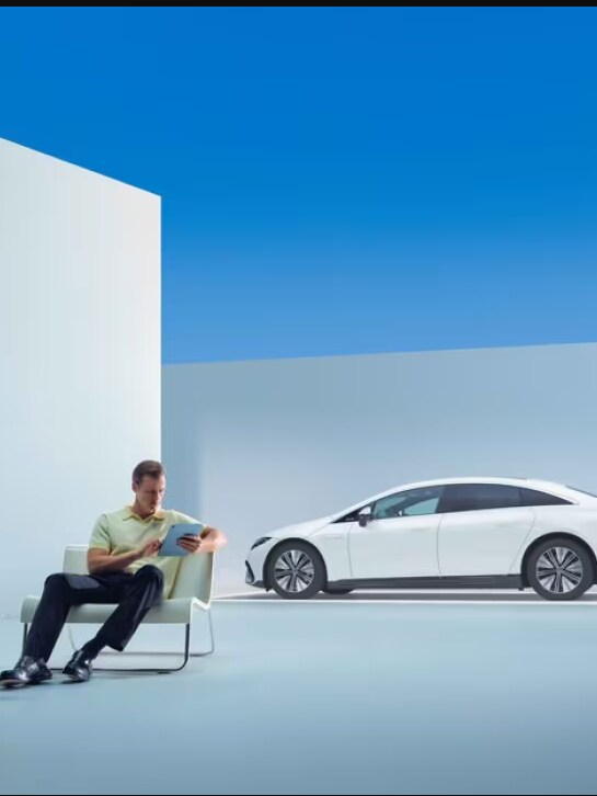 A man inspects a Mercedes Benz.