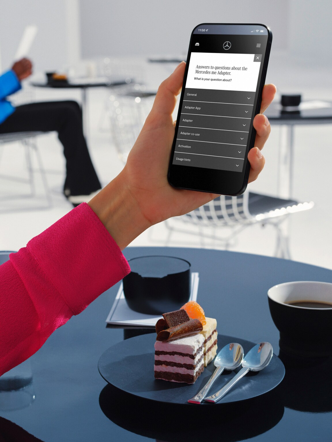 A young man reads answers to frequently asked questions about the Mercedes-Benz Adapter on his smartphone.