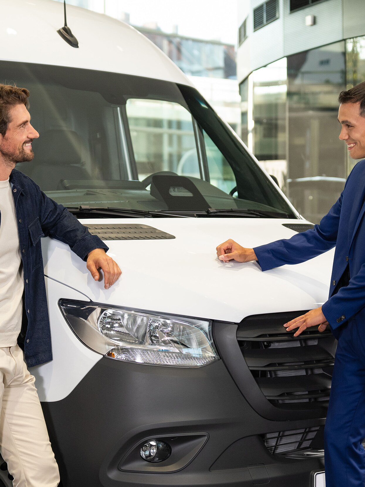 Two men standing in front of a Mercedes-Benz Sprinter