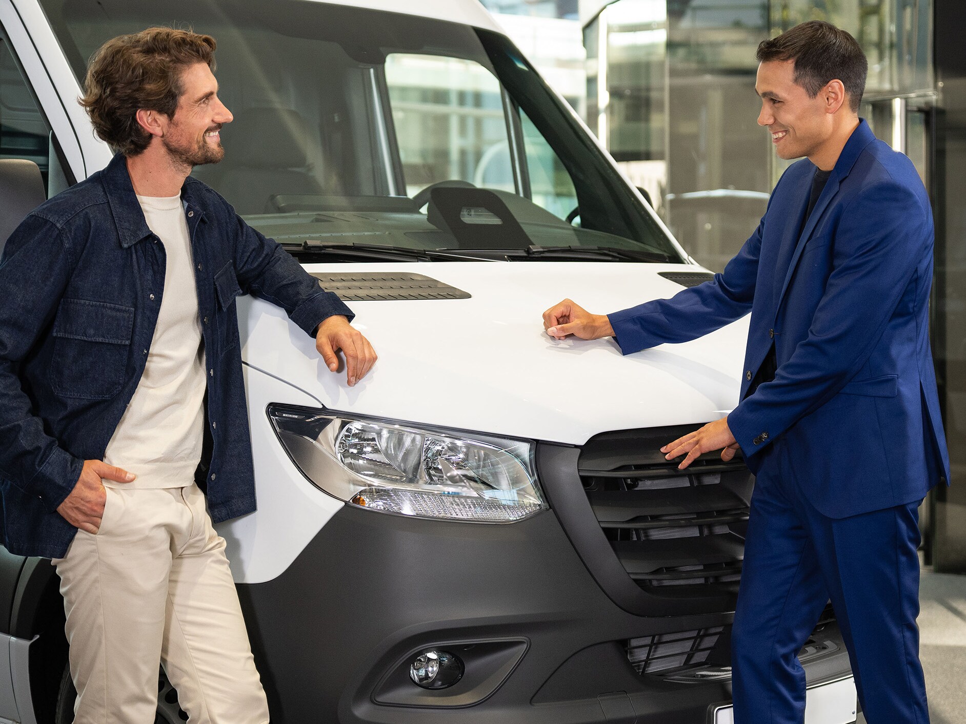 Two men standing in front of a Mercedes-Benz Sprinter