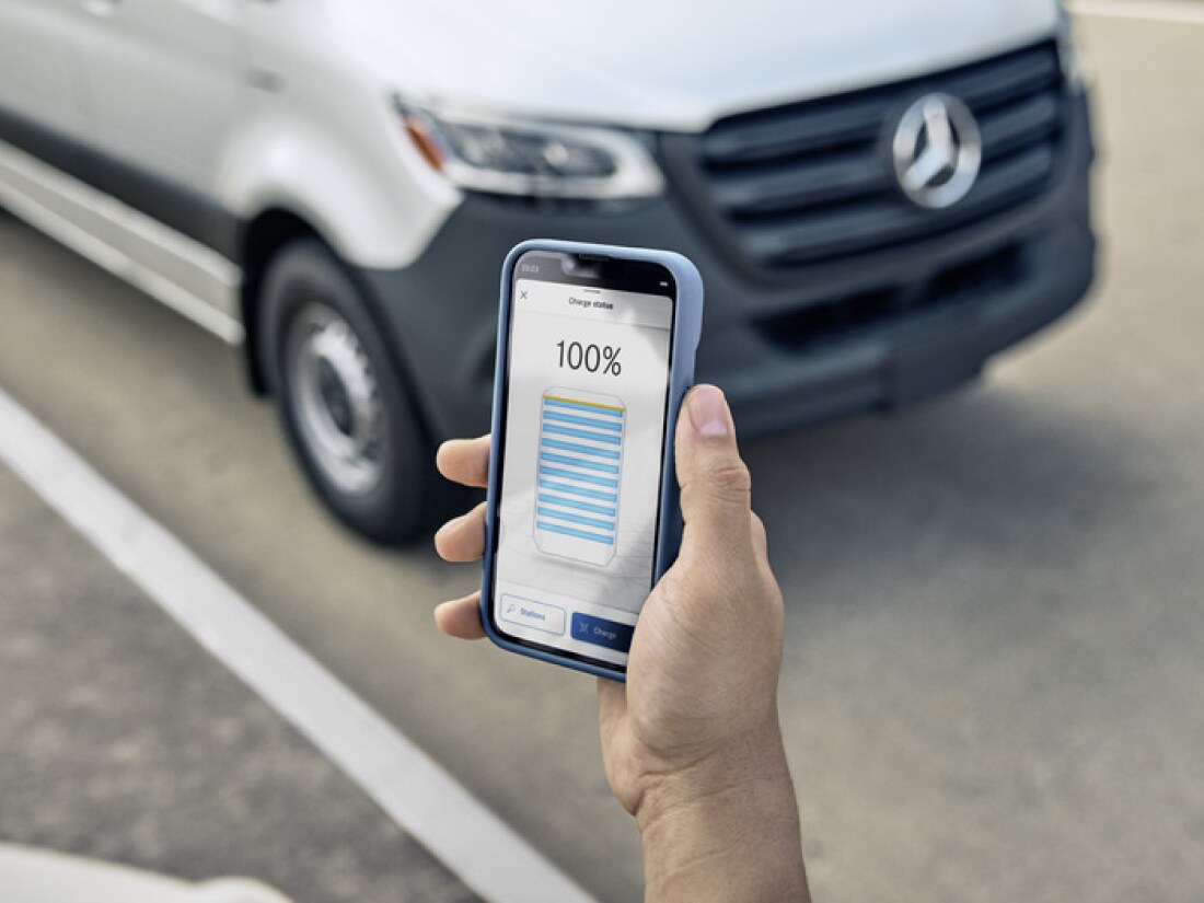 A person holding a phone with Mercedes me app on the screen